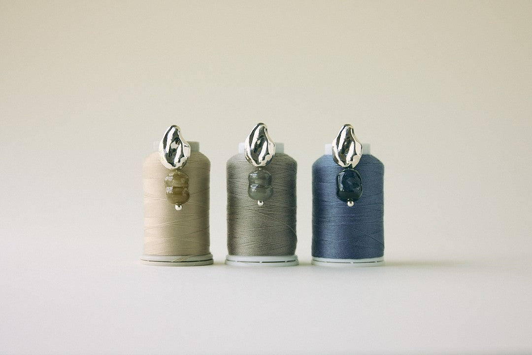 Three ConsiderBeyond x CLED earrings on thread spools