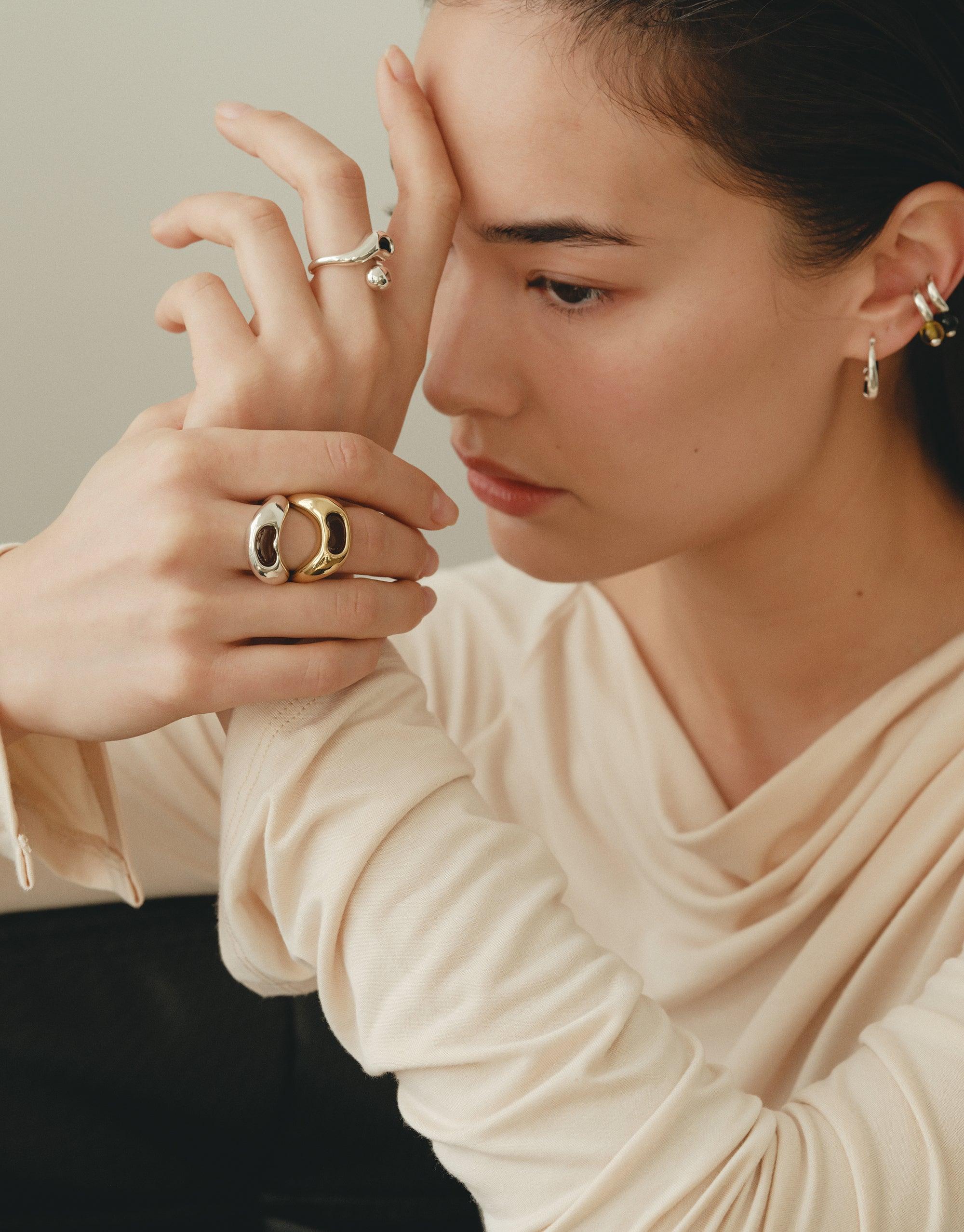Elegant model showcasing Bean Ring, a nature-inspired jewelry piece with organic shapes and soft curves. The ring's unique design reflects the beauty of legumes, symbolizing growth and transformation. Paired with complementary earrings and rings for a complete look. CLED Bean Ring