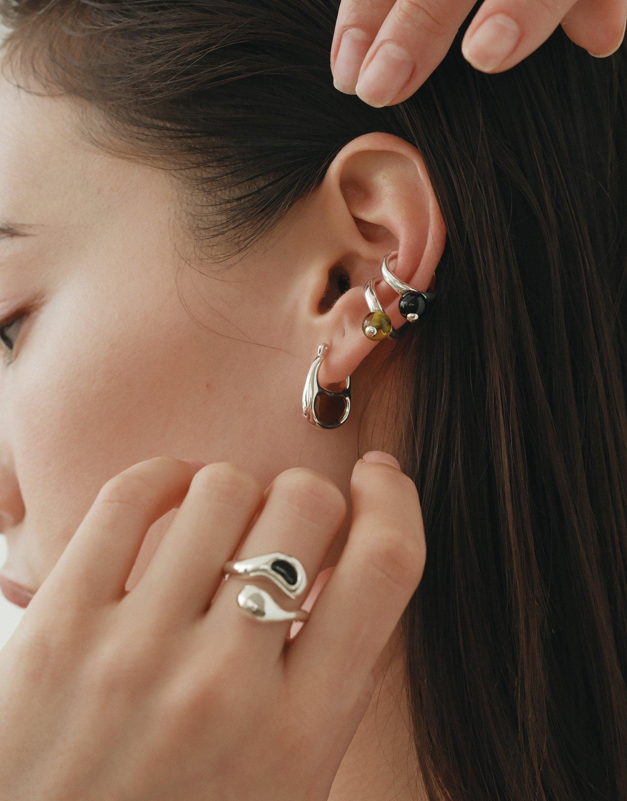 Sprout Ring showcased on a woman's hand, reflecting nature's elegant curves and growth. Inspired by legumes, this eco-conscious piece embodies transformation, crafted from repurposed glass by CLED.