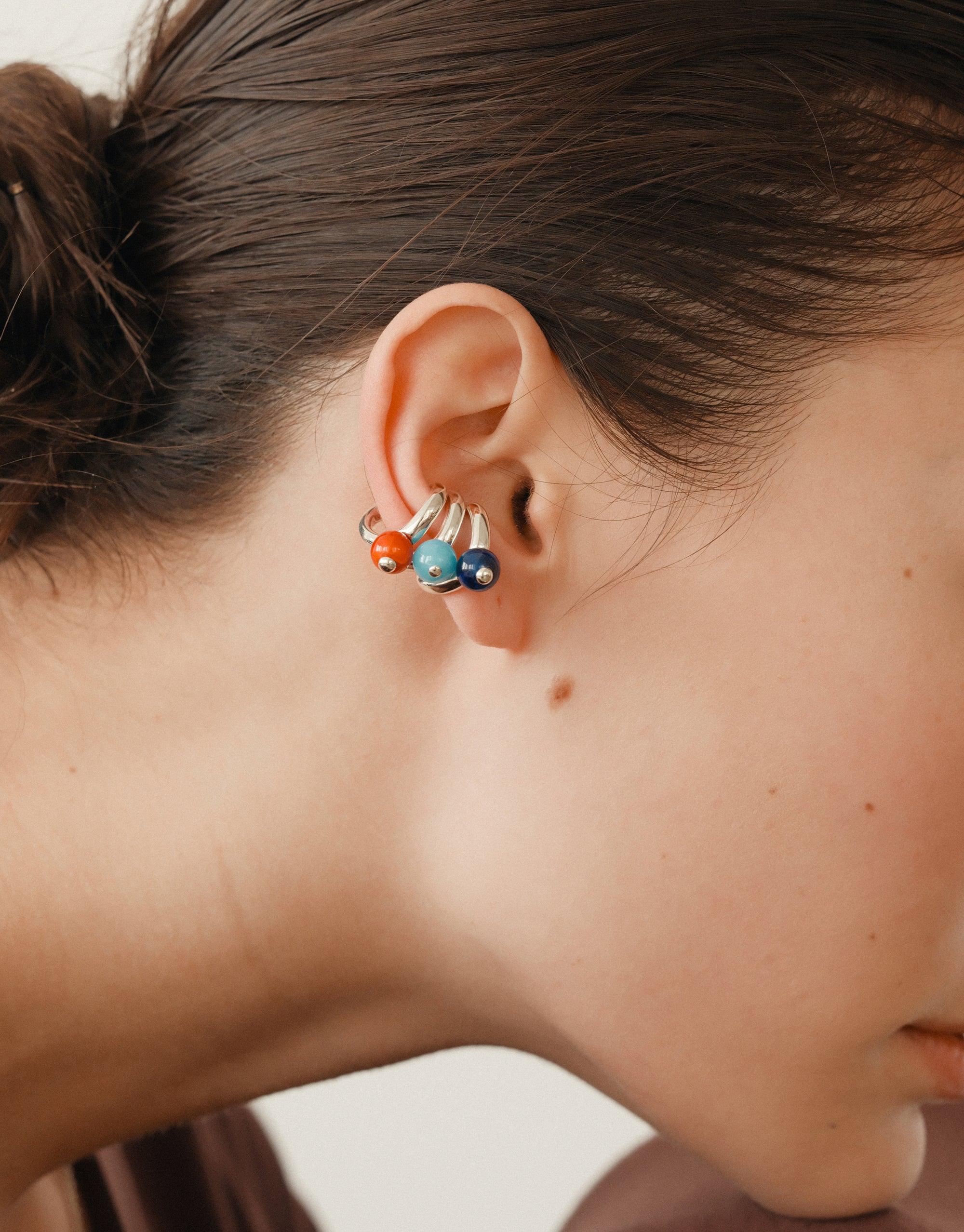 Close-up of ear wearing colorful Pea Ear Cuff | Small, showcasing organic shapes inspired by legume plants. Intricate design with soft curves in vibrant hues, capturing nature's creativity and transformation. Elegant accessory for nature-inspired style. CLED