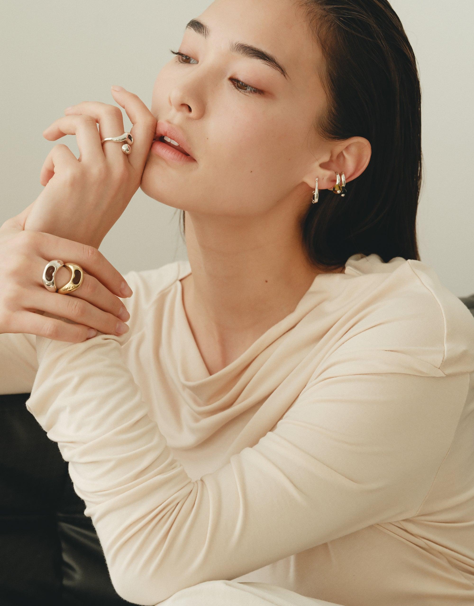 Model wearing elegant Pea Ear Cuff | Small, showcasing its delicate design inspired by legume shapes. The cuff complements other nature-inspired jewelry pieces, highlighting the collection's organic aesthetic. Perfect for those seeking unique, nature-inspired accessories. CLED