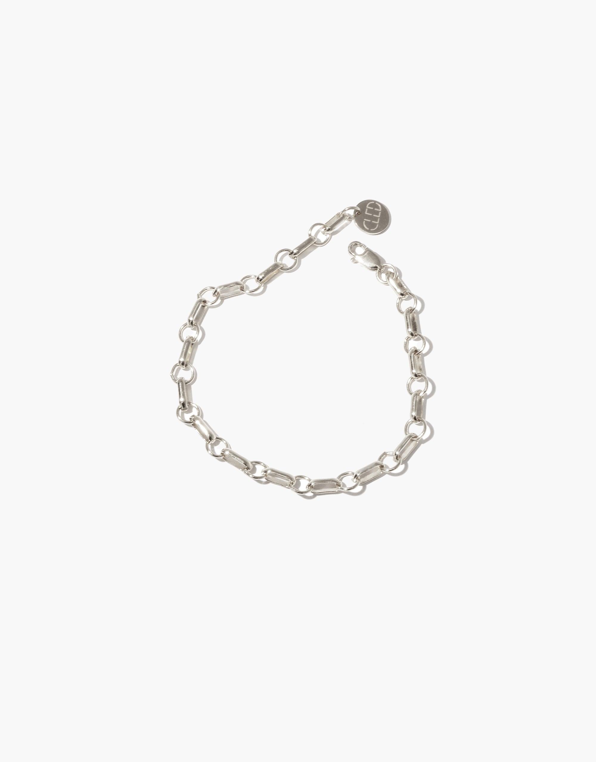 Sleek silver chain bracelet with oval links and small round charm, perfect for customization or wearing alone. Versatile accessory for creating a bold statement. Icon Chain Bracelet | A by CLED