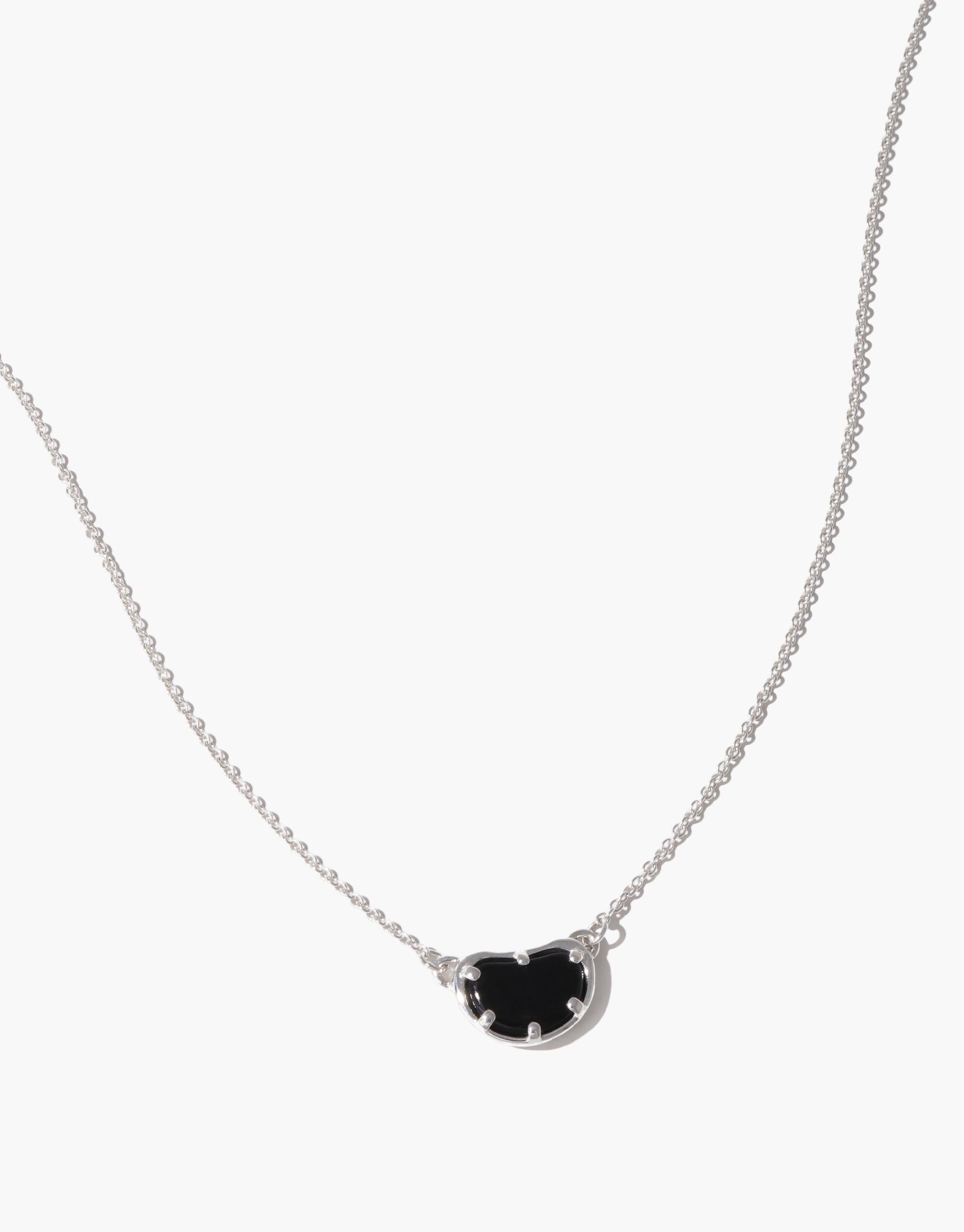 Elegant Bean Necklace featuring a delicate silver chain and a unique black bean-shaped pendant. The pendant's organic form captures nature's creativity, symbolizing growth and transformation. A sophisticated accessory inspired by the soft curves of legumes, perfect for nature lovers. Bean Necklace by CLED