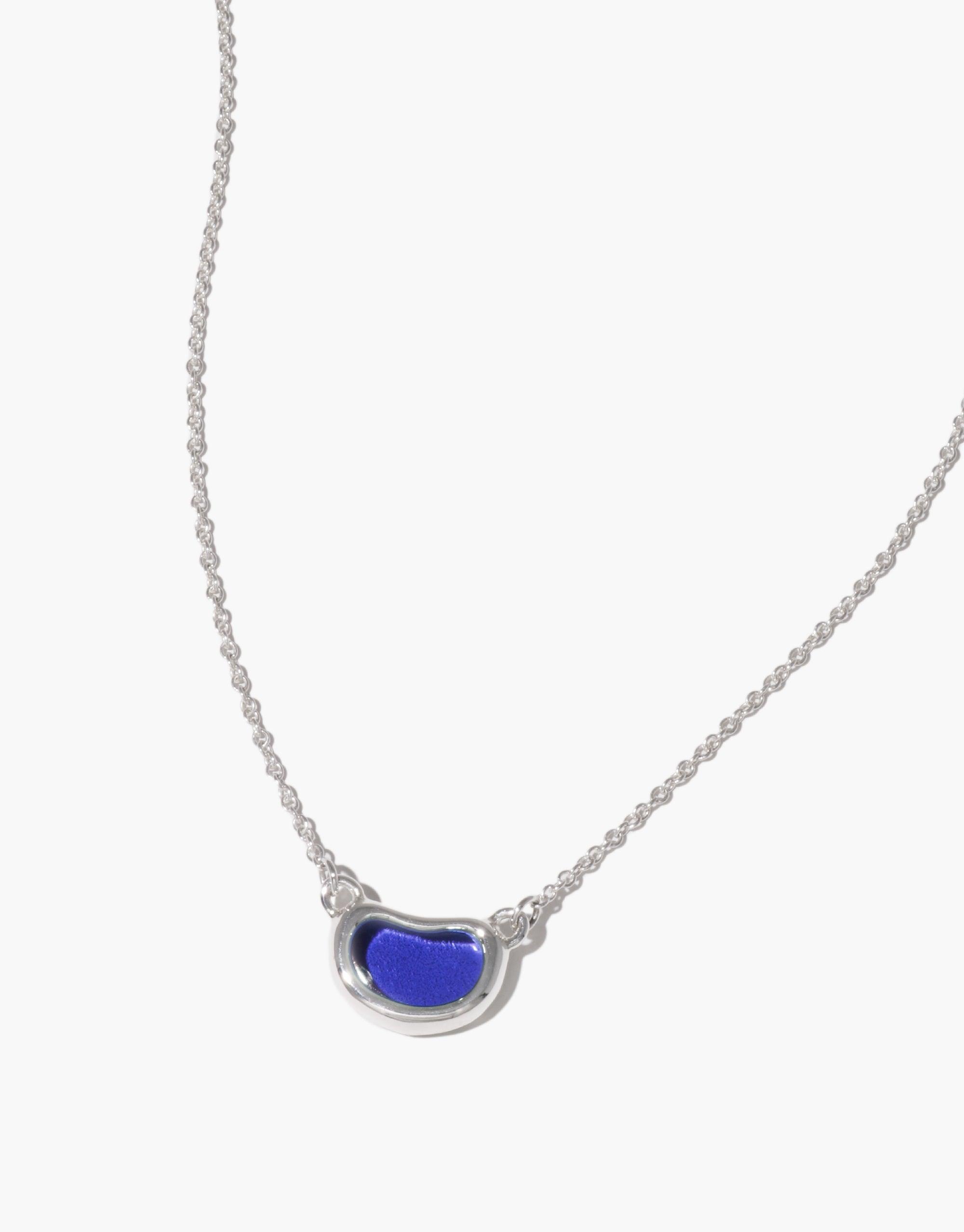 Elegant silver necklace featuring a unique bean-shaped pendant with vibrant blue enamel, inspired by nature's organic forms. Delicate chain complements the minimalist design. Bean Necklace showcases growth and transformation in jewelry. CLED