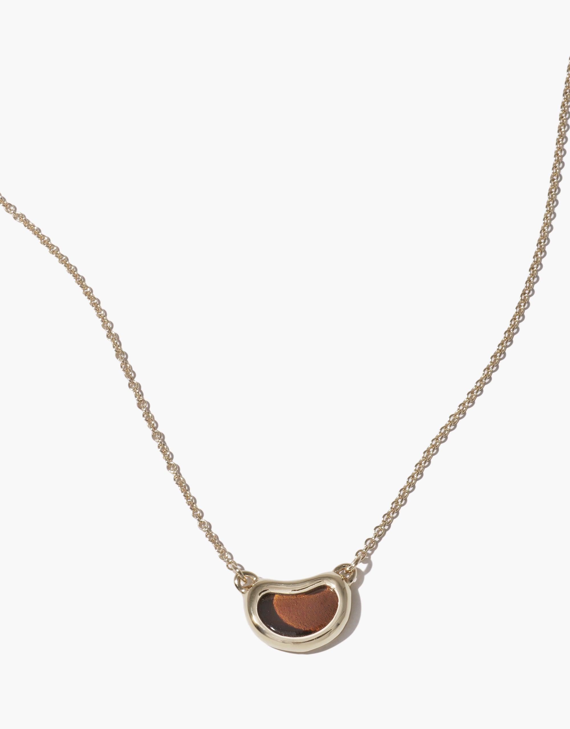 Elegant Bean Necklace featuring a delicate silver chain with a unique bean-shaped pendant, showcasing organic curves and a warm copper-toned inlay. Nature-inspired jewelry piece capturing the essence of growth and transformation. Bean Necklace by CLED