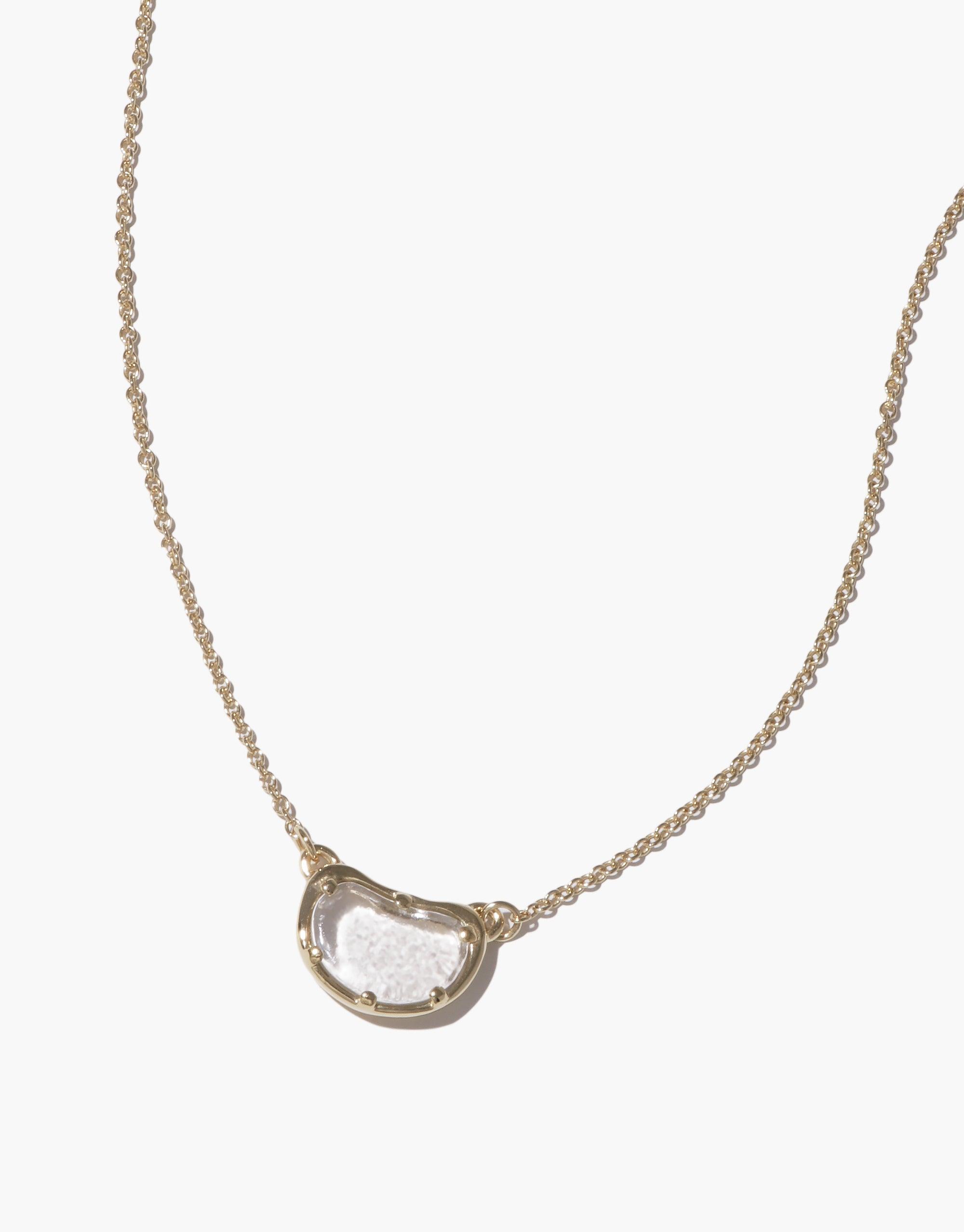 Elegant Bean Necklace featuring a delicate gold chain with a single, organic-shaped pearl pendant reminiscent of a legume. Showcases nature-inspired design, embodying growth and transformation. Unique jewelry piece capturing the essence of natural beauty. Bean Necklace by CLED.