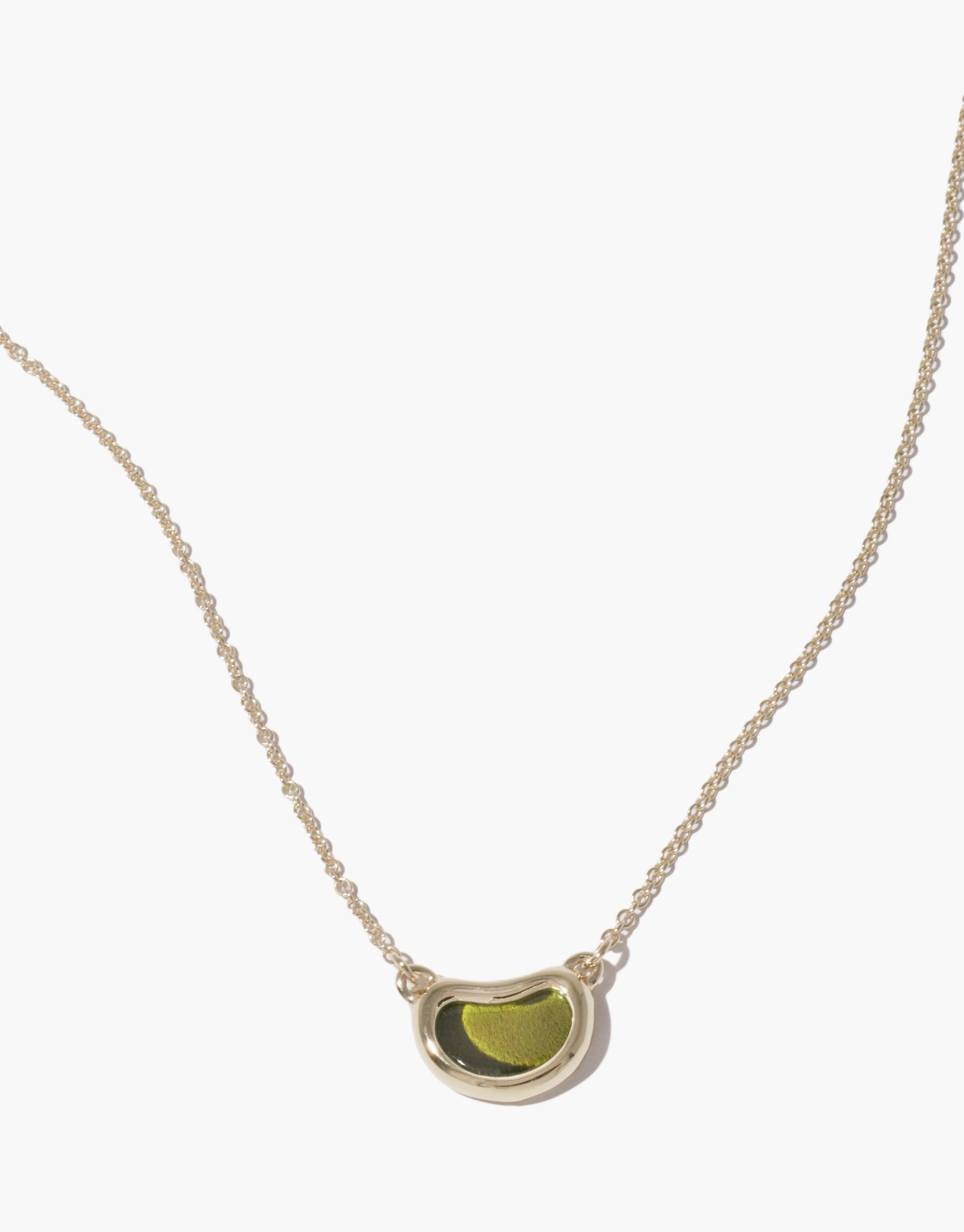 Elegant Bean Necklace featuring a delicate silver chain and unique bean-shaped pendant with green center, inspired by nature's organic forms. Perfect accessory for a subtle, sophisticated look. Bean Necklace by CLED