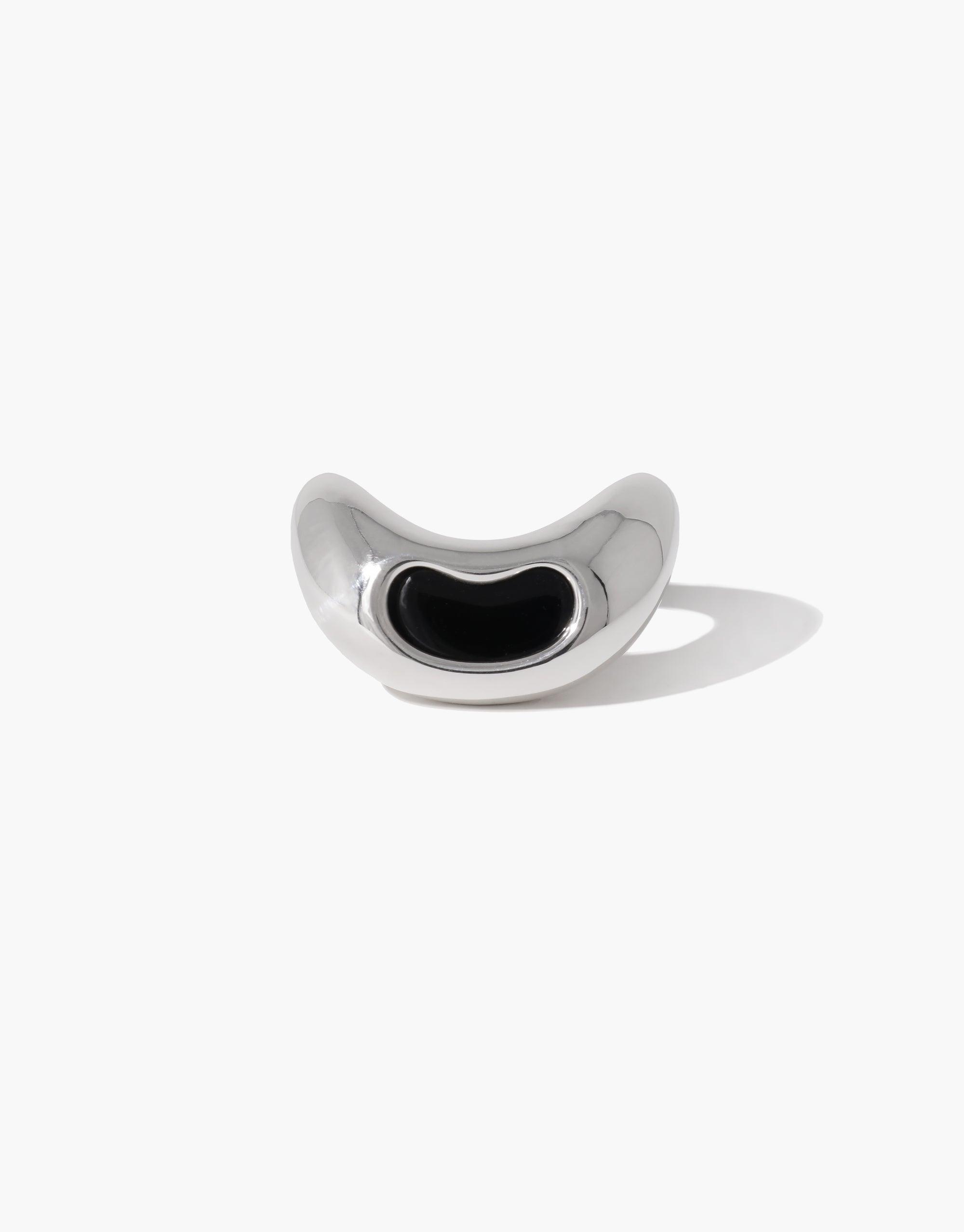 Sleek silver Bean Ring with organic shape and black center, inspired by legume plant growth. Unique design capturing nature's creativity and transformation. Elegant jewelry piece reflecting natural beauty. CLED Bean Ring.