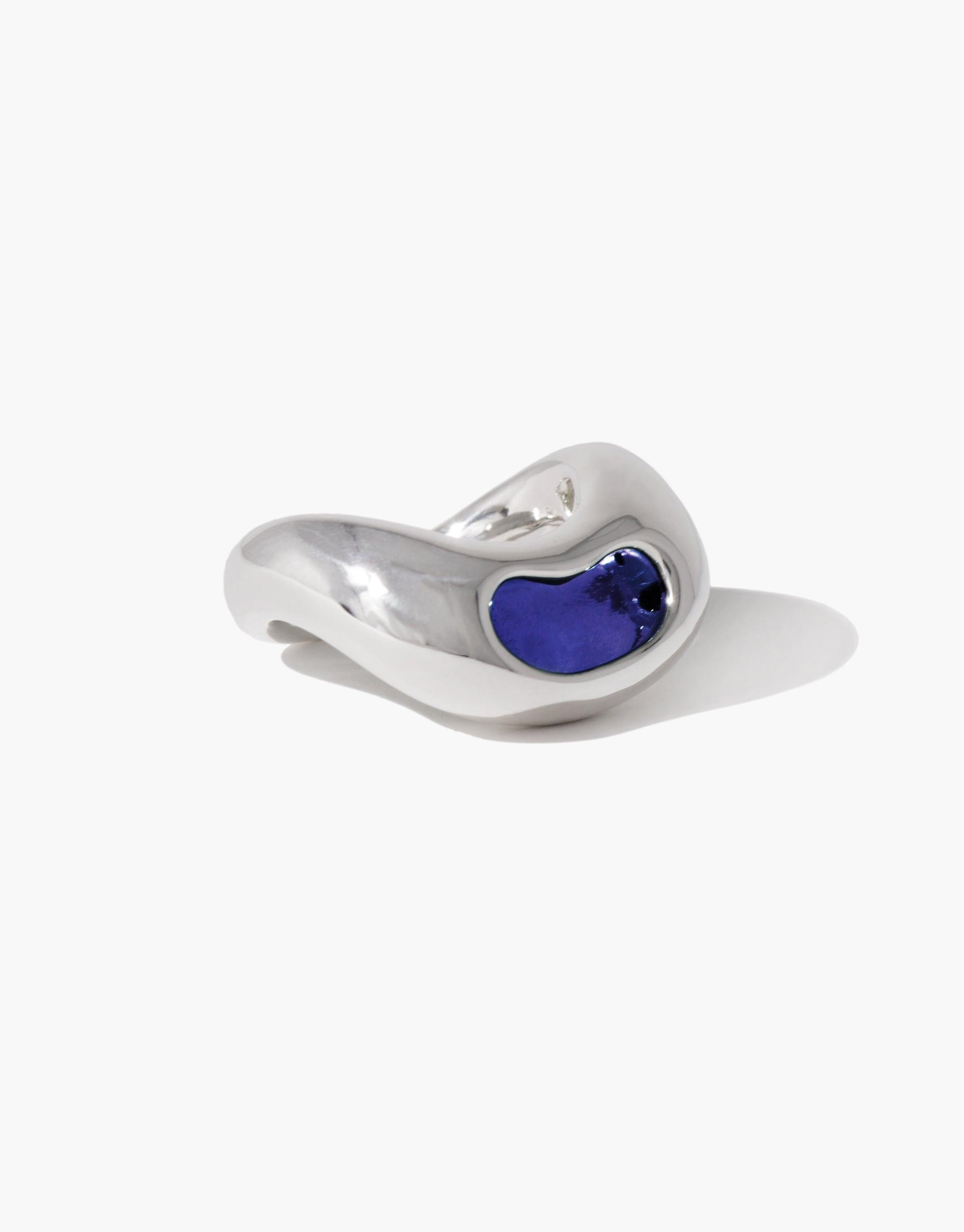 Elegant silver Bean Ring featuring a vibrant blue inlay, showcasing organic curves inspired by nature's legume shapes. Unique jewelry piece blending contemporary design with natural inspiration. Handcrafted accessory perfect for adding a touch of sophistication to any outfit. CLED