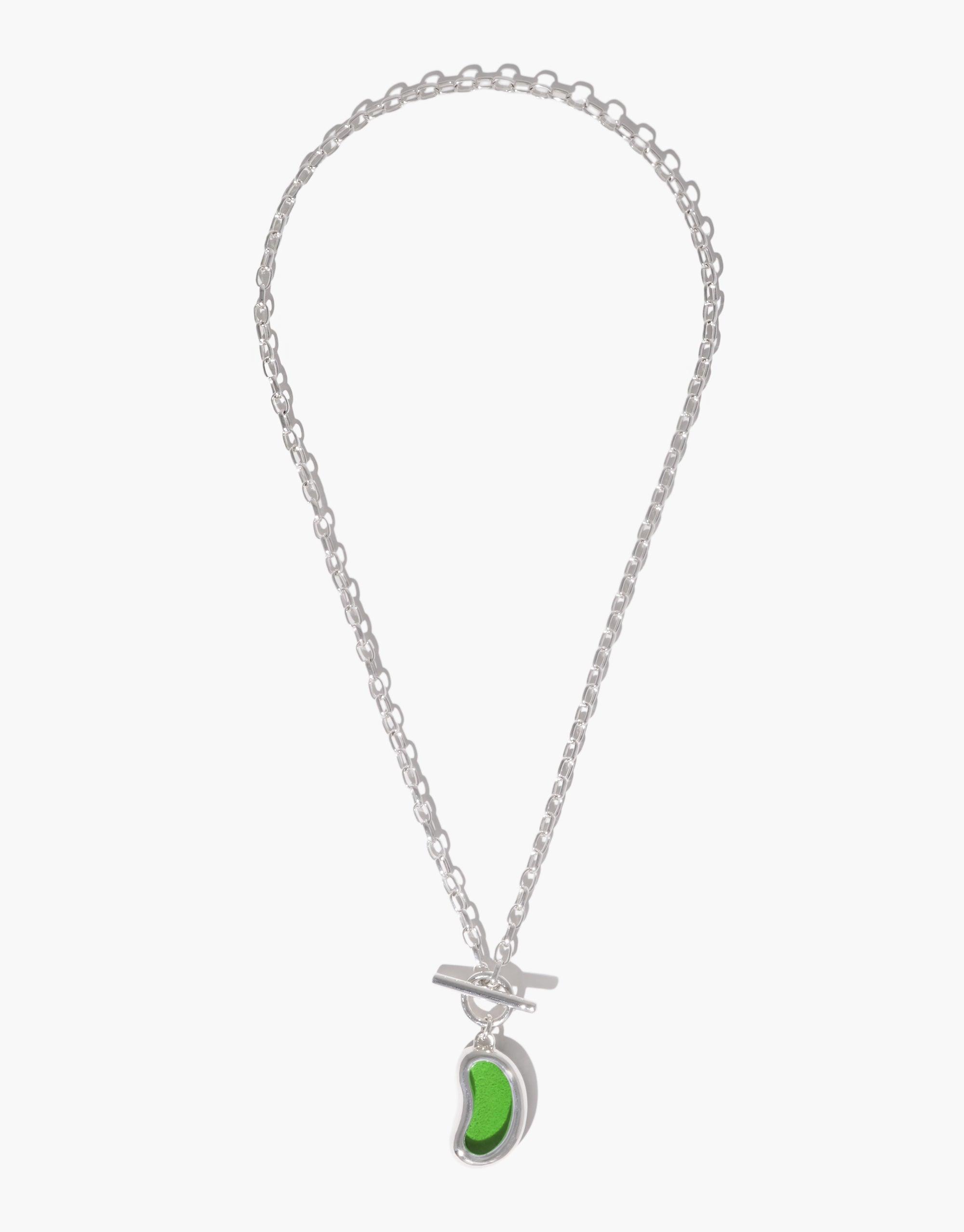 Silver chain necklace with a green bean-shaped toggle pendant, inspired by nature's organic forms. The Bean Toggle Necklace features a unique legume-inspired design, showcasing growth and transformation. Elegant and versatile accessory for nature lovers. CLED