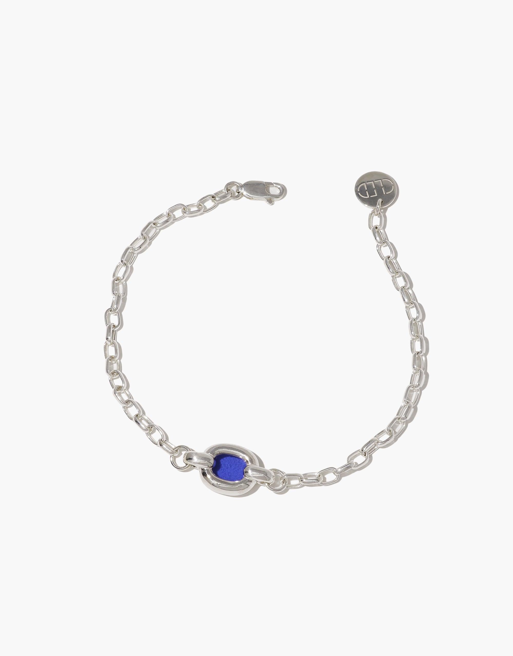 Elegant silver chain bracelet with a single blue bead centerpiece, showcasing minimalist design and sustainable craftsmanship. Core Loop Bracelet symbolizes unity and upcycling, perfect for everyday wear. CLED