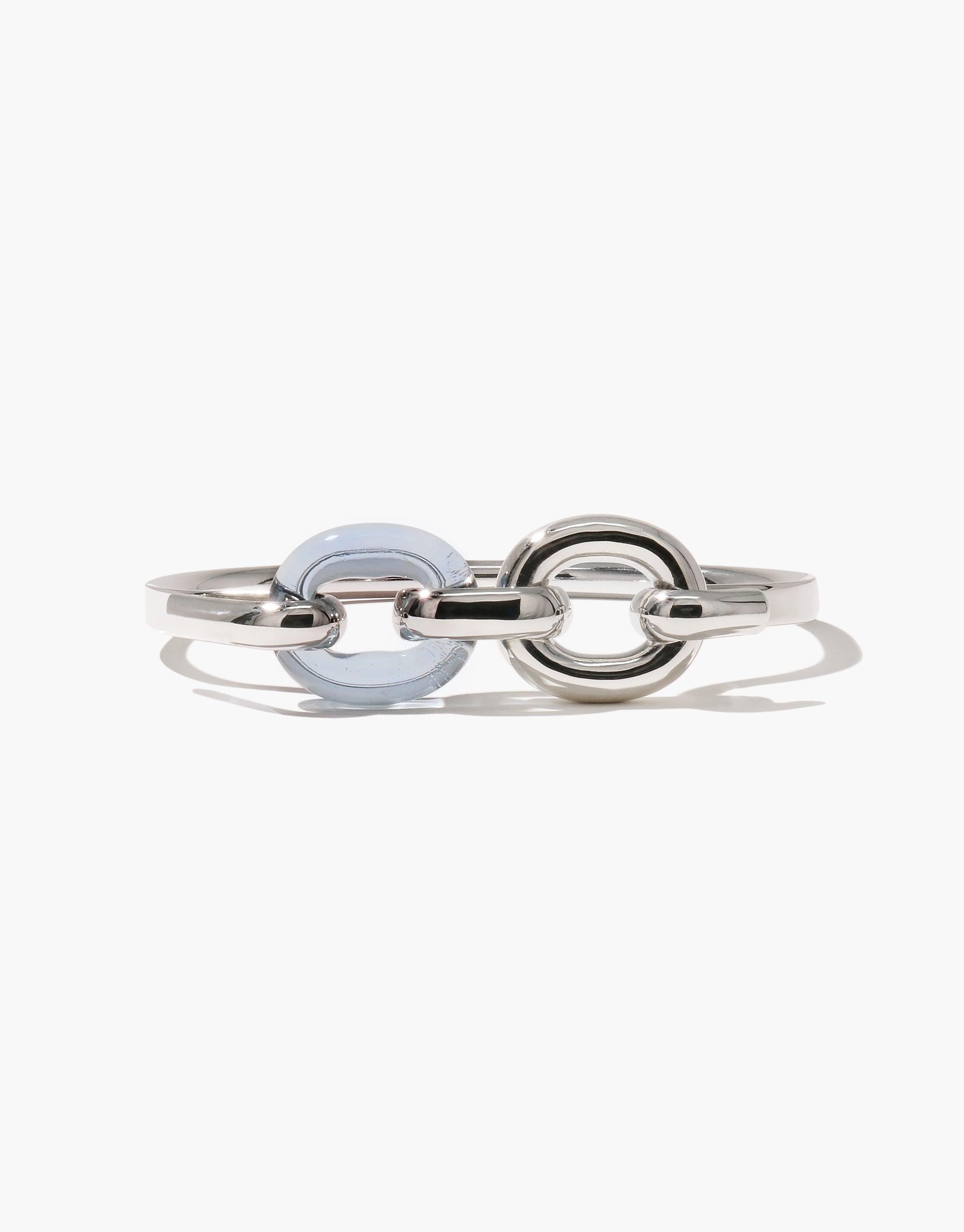 Sleek Loop Hook Bracelet featuring interlocking silver and pale blue circular elements, symbolizing unity and connection. Elegant upcycled design showcases sustainable fashion. Modern accessory perfect for everyday wear. Loop Hook Bracelet by CLED.