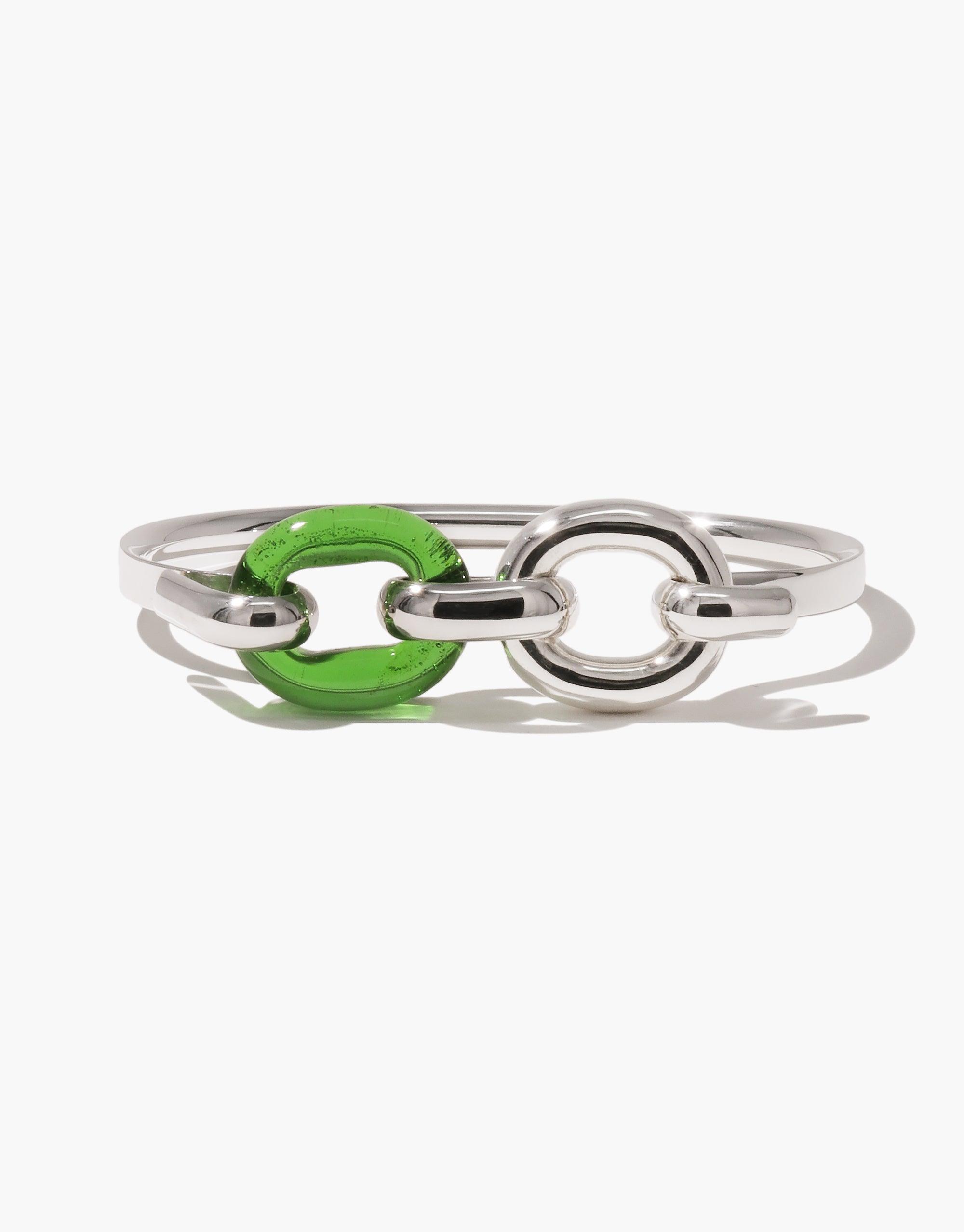 Sleek silver bracelet with three interlocking loops, featuring a vibrant green glass element, showcasing sustainable design and unity. Loop Hook Bracelet by CLED