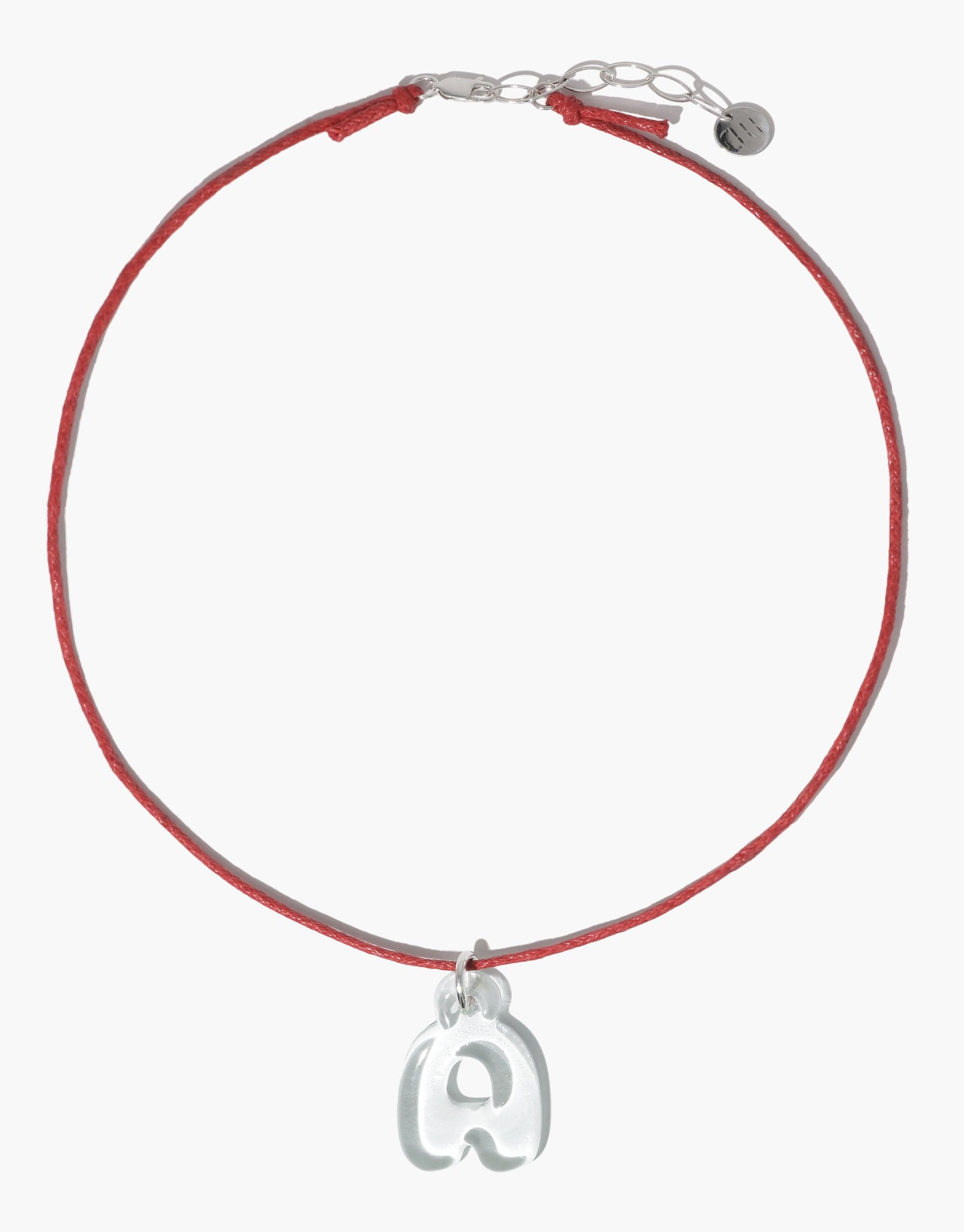 Red cord necklace with silver clasp and adjustable chain, featuring a bubble-shaped letter 'A' charm made from recycled glass. Minimalist and eco-friendly design for the Letter Charm | Alphabet product by CLED.