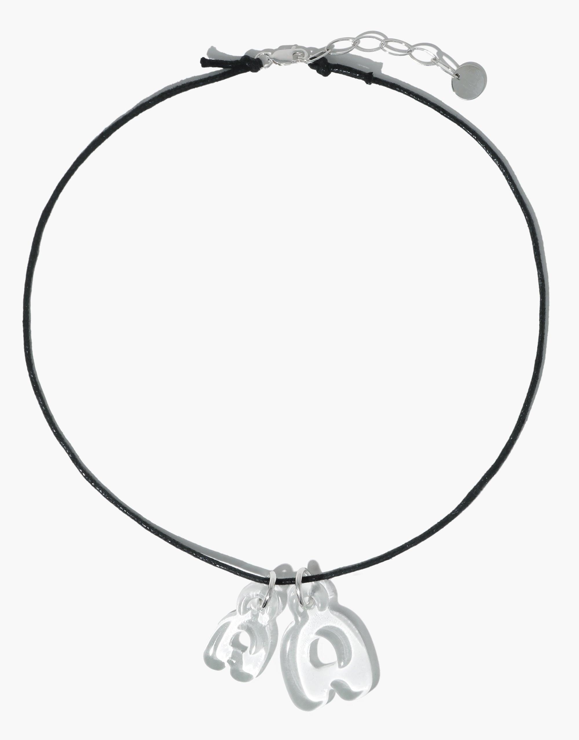 Sleek black cord necklace with two transparent bubble letter charms, showcasing the Letter Charm | Alphabet product. Adjustable silver chain clasp for versatile styling. Eco-friendly and playful accessory made from recycled materials by CLED.