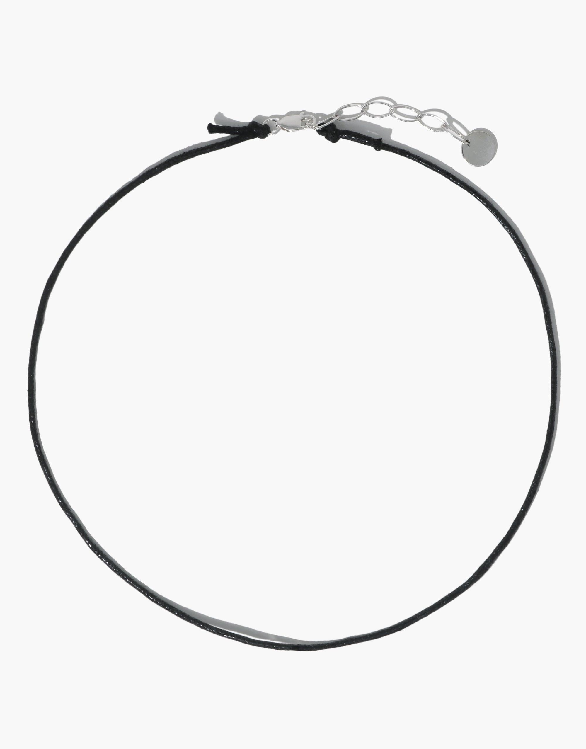 Adjustable black cotton cord necklace with silver clasp and extender chain, ideal for attaching charms. Versatile 16-18 inch length. Minimalist design for everyday wear. Sustainably crafted with plant-based wax finish. Cord Necklace by CLED.