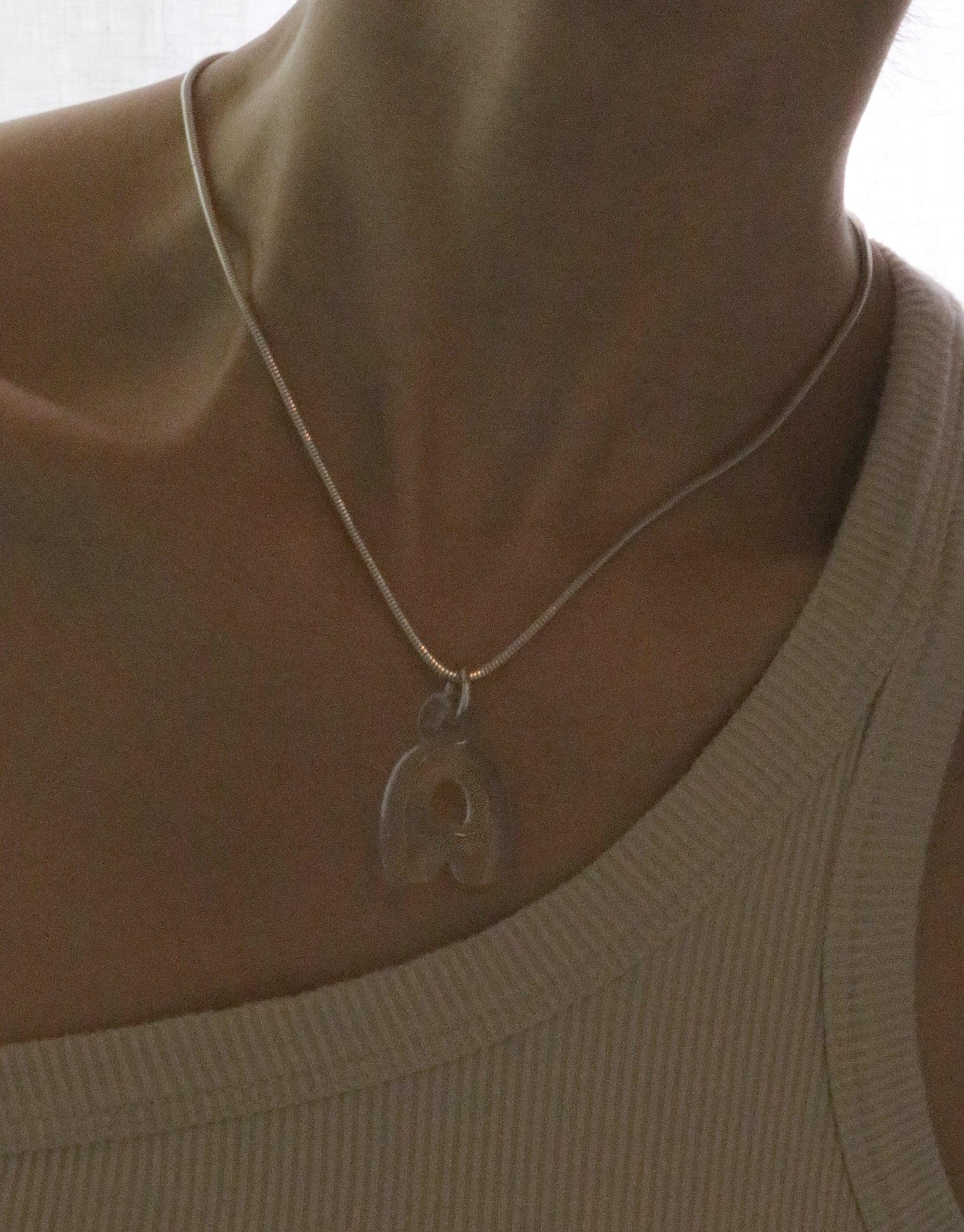 Sleek silver Snake Chain Necklace worn on mannequin, showcasing adjustable length and compatibility with charms. Ideal for versatile styling and personalization. Perfect accessory for everyday wear or special occasions. Snake Chain Necklace by CLED.