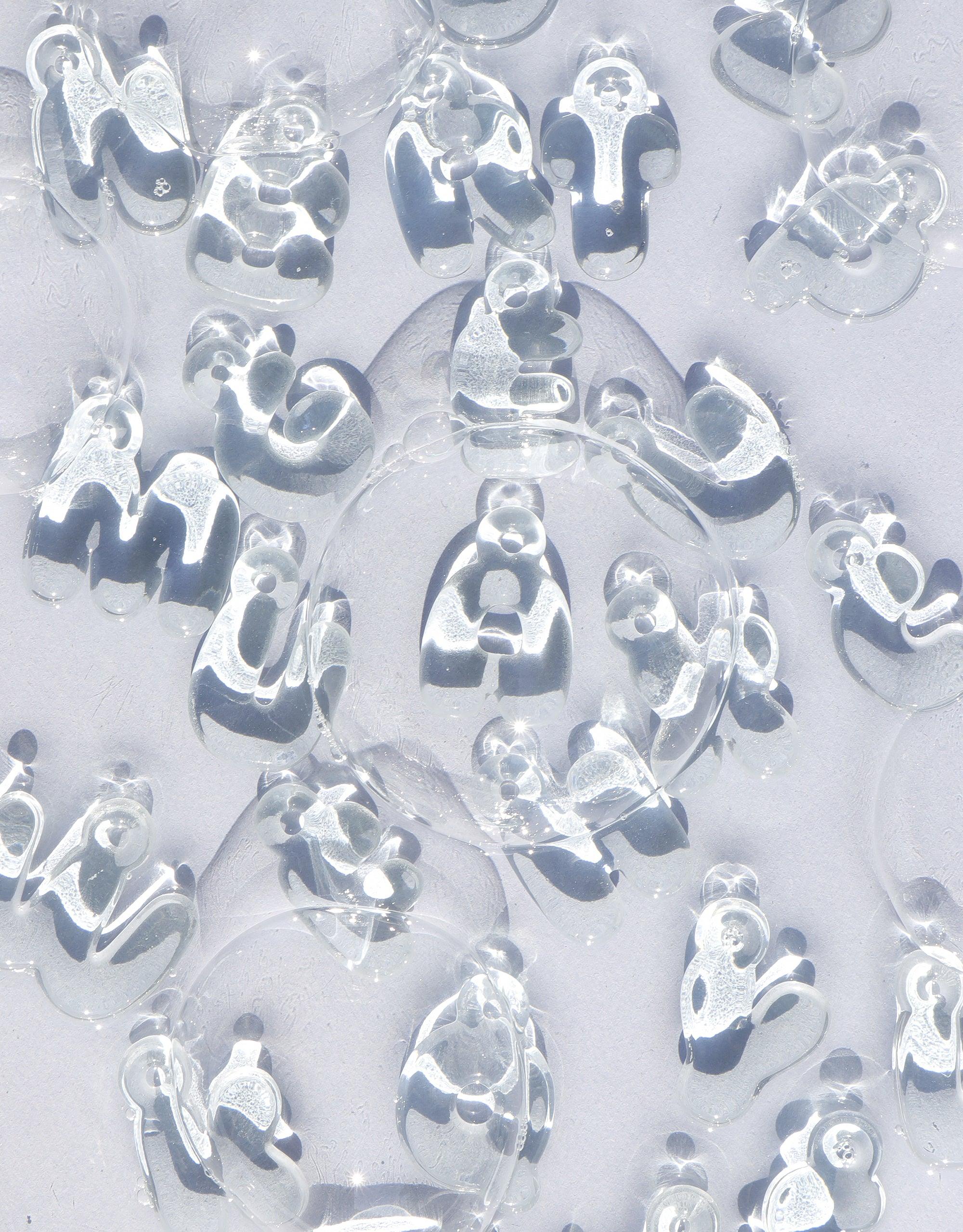 Transparent bubble-shaped letter charms made from recycled window glass, showcasing various alphabet characters. Eco-friendly and playful design for personalized jewelry. Letter Charm | Alphabet by CLED