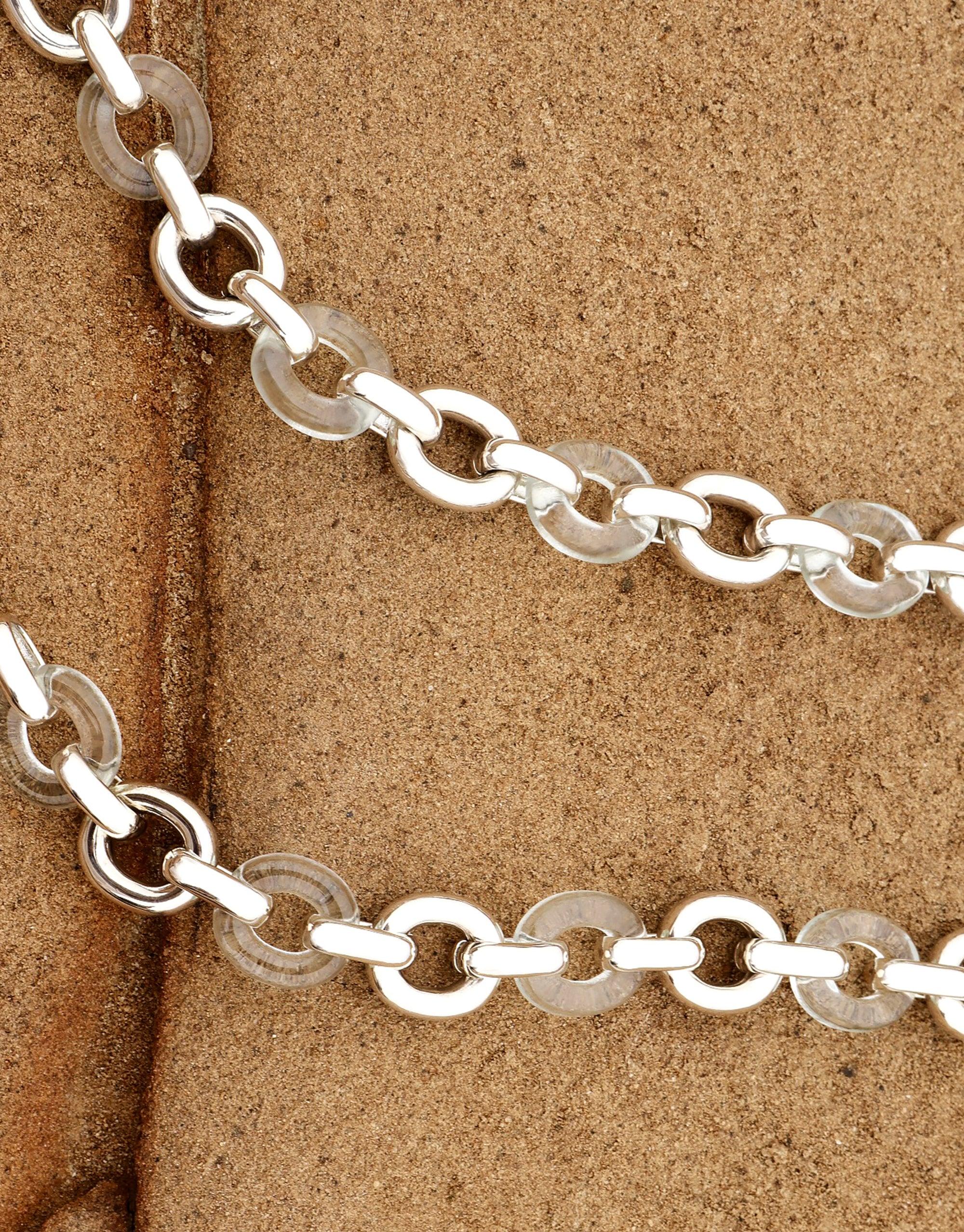 Connected Loop Necklace with alternating silver metal and clear glass links, showcasing an eco-friendly design against a textured beige background. Symbolizes unity and upcycling in CLED's Mixed Metal & Glass Connected Loop Necklace.