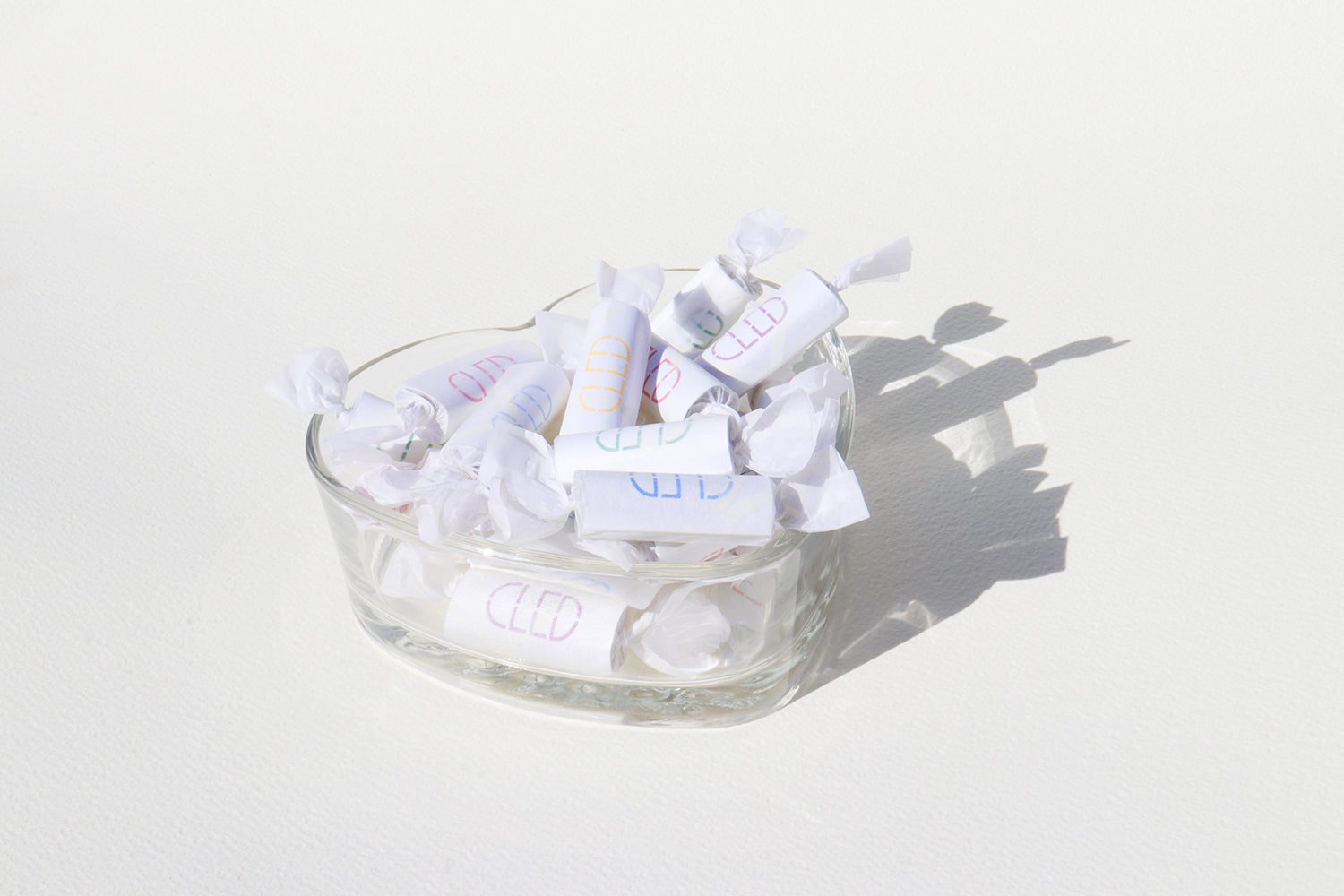 A glass bowl filled with an assortment of white candies, showcasing their glossy texture and inviting appearance.