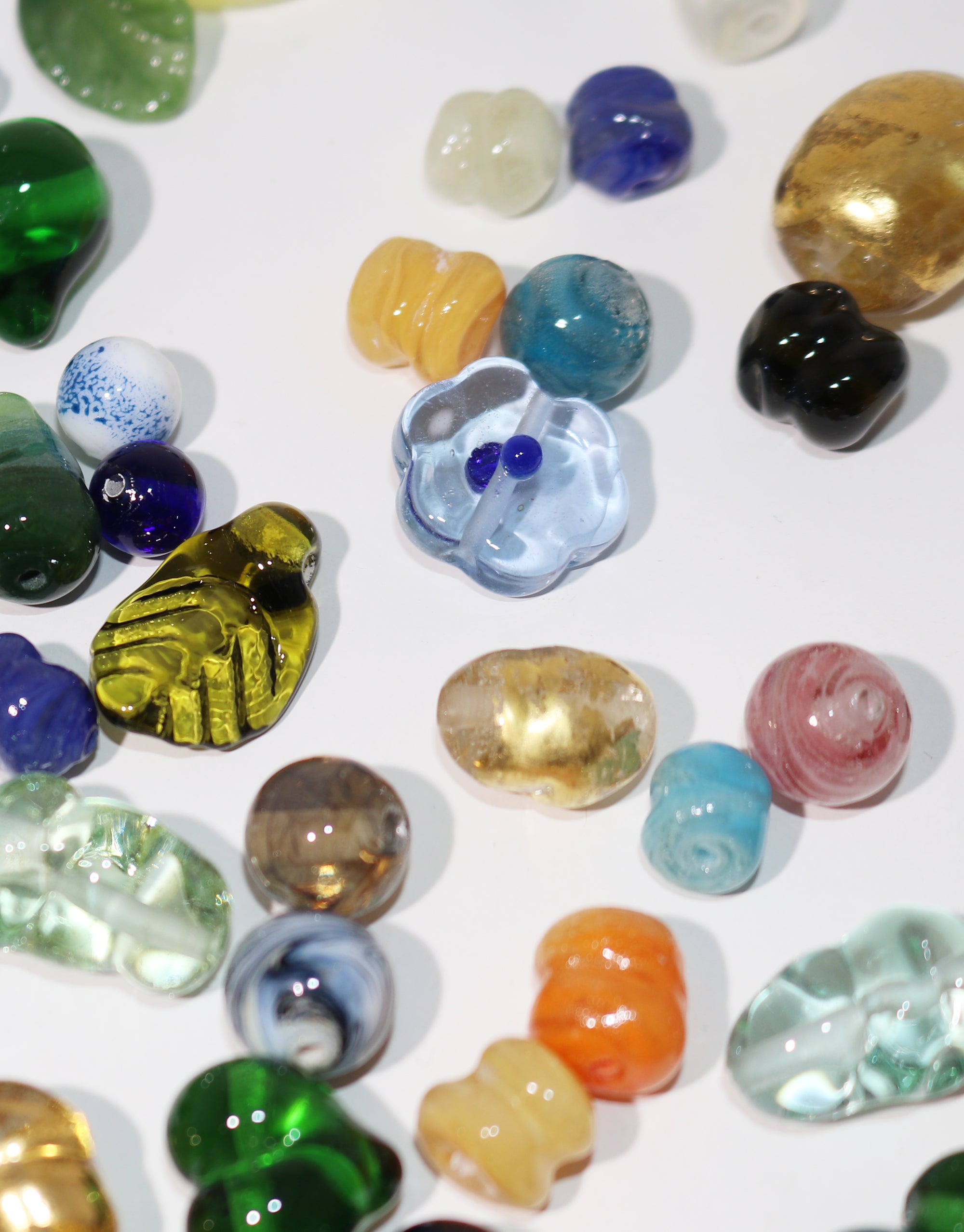 A vibrant assortment of colorful glass beads arranged together, showcasing a variety of hues and textures.