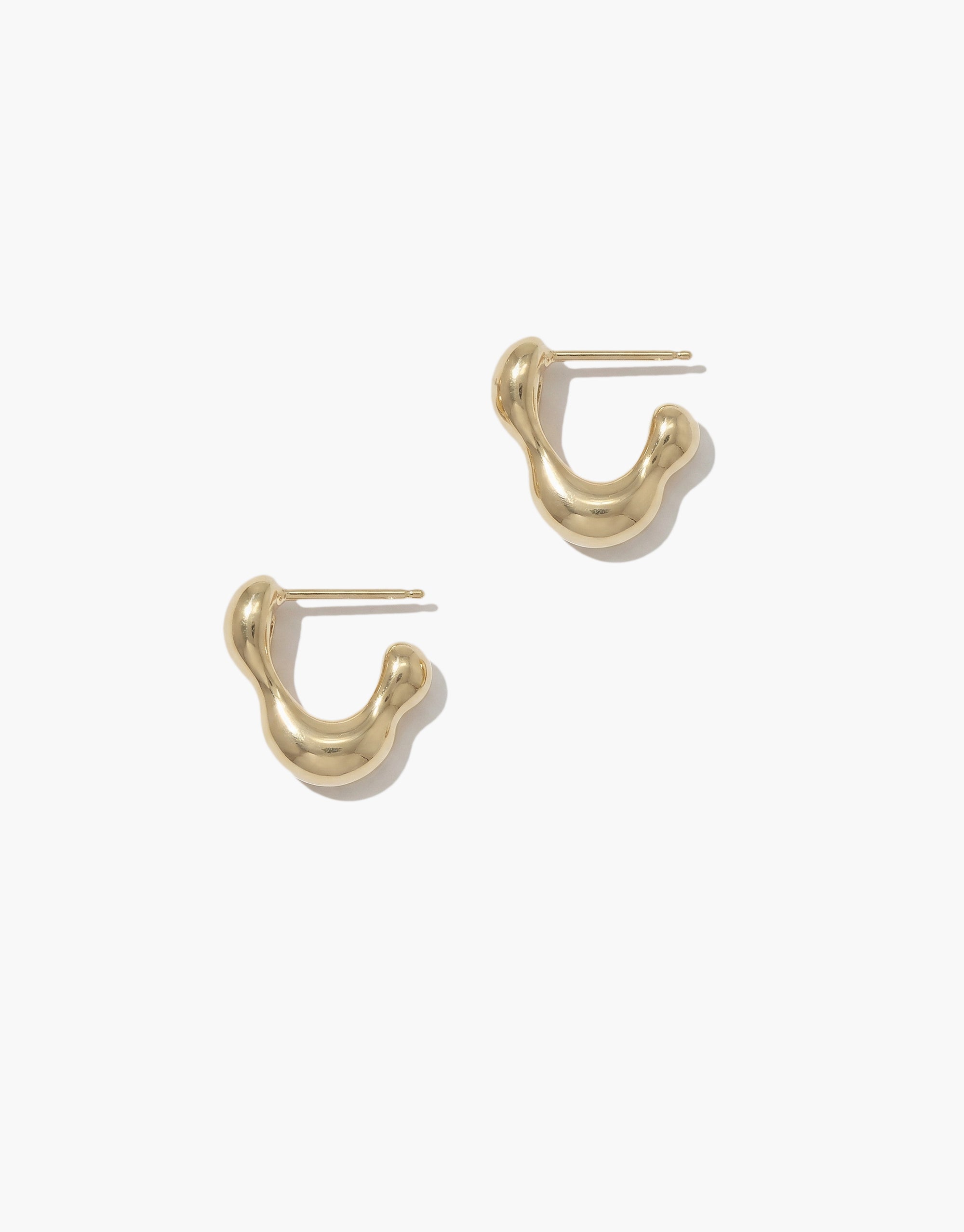 Pair of gold plated hoop earrings on a white background