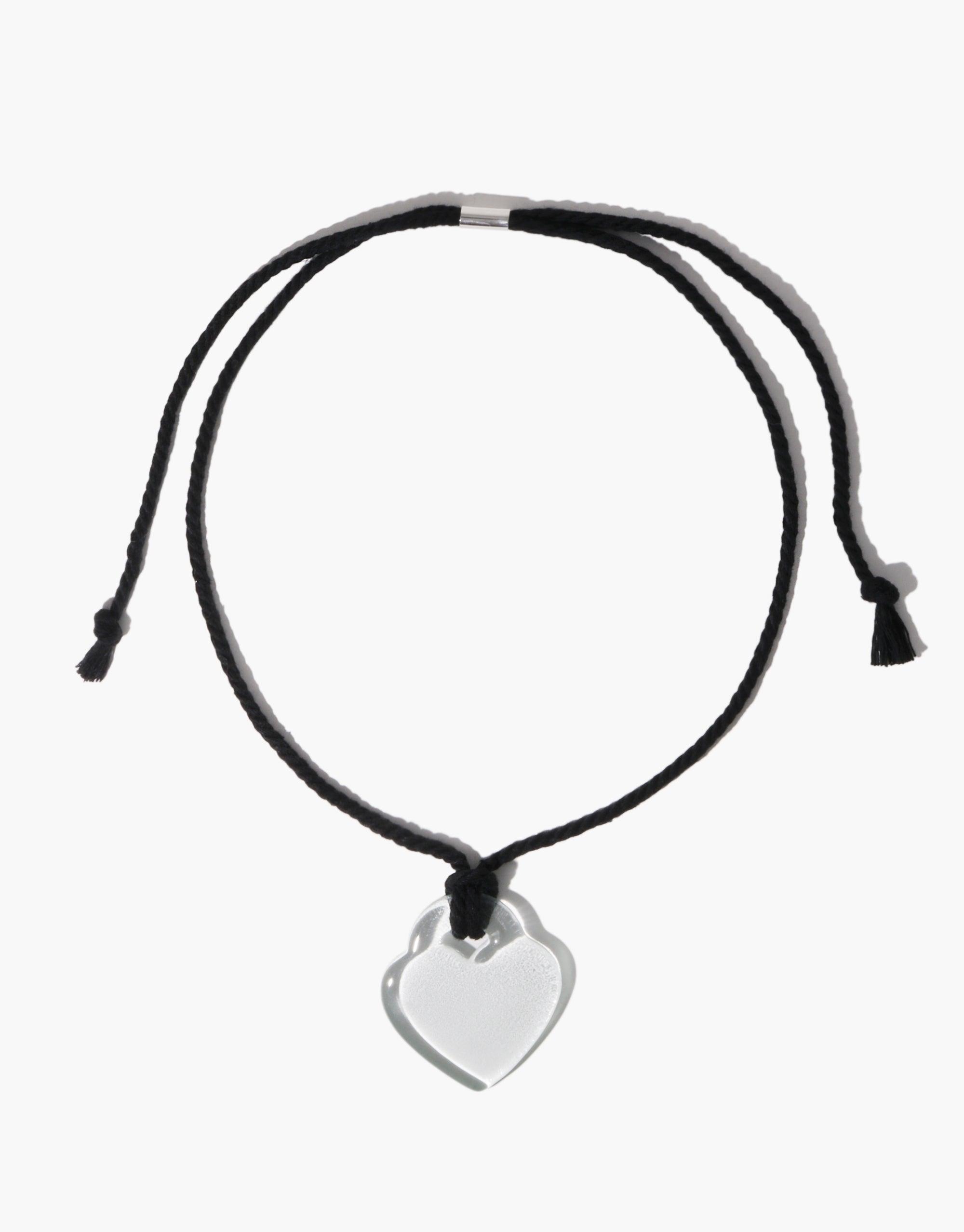 Elegant Clear Heart Necklace featuring a transparent heart-shaped pendant on a sleek black adjustable cord. Nature-inspired design showcasing organic shapes and soft curves. Versatile accessory symbolizing growth and transformation. Clear Heart Necklace by CLED.