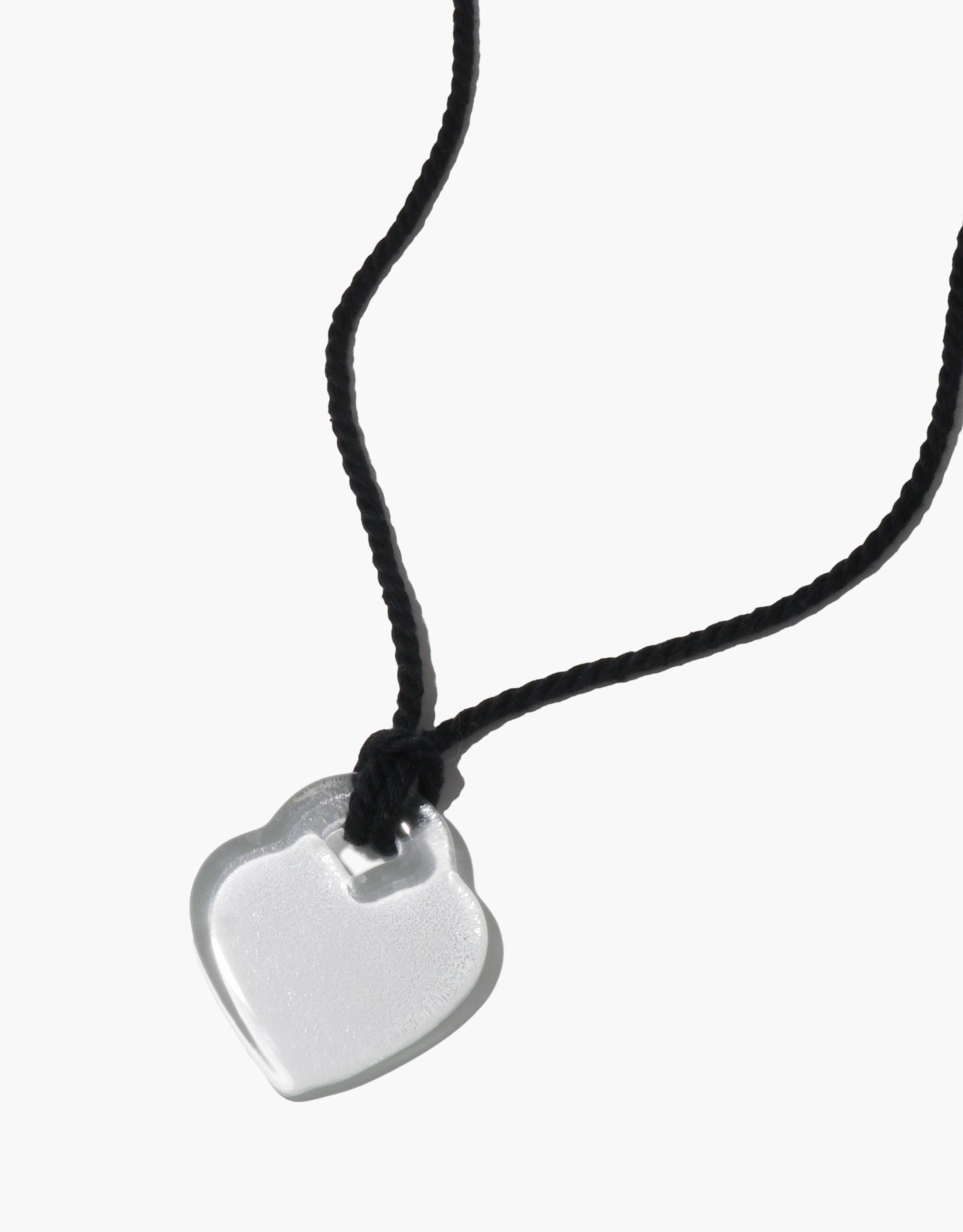 Clear heart-shaped pendant on black cord necklace, showcasing minimalist design inspired by nature's organic shapes. Elegant and versatile Clear Heart Necklace, perfect for everyday wear or special occasions. CLED