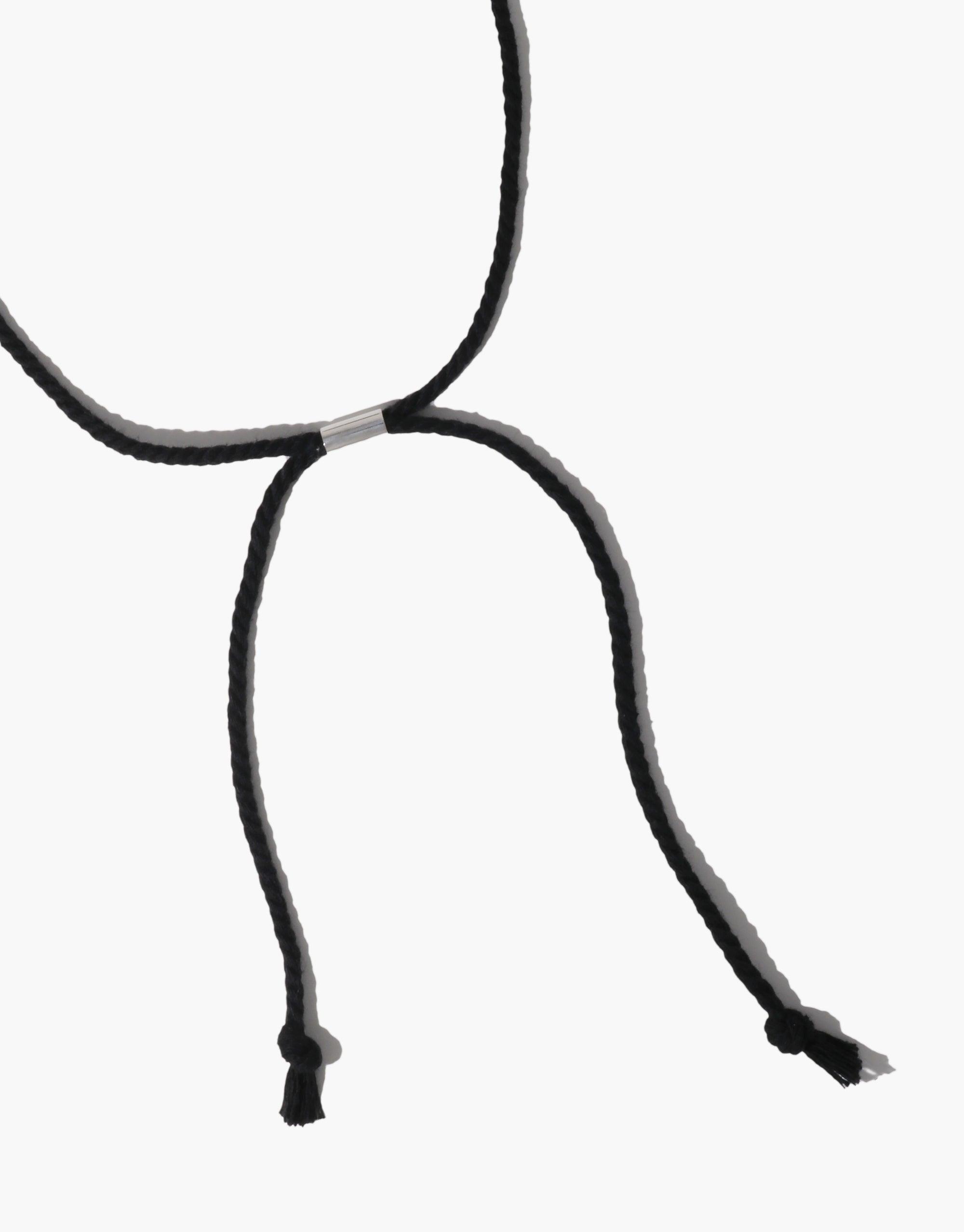 Clear Heart Necklace featuring a sleek black cord design with adjustable length. Minimalist and elegant jewelry piece inspired by nature's organic shapes. Versatile accessory for any outfit, showcasing the beauty of simplicity. CLED