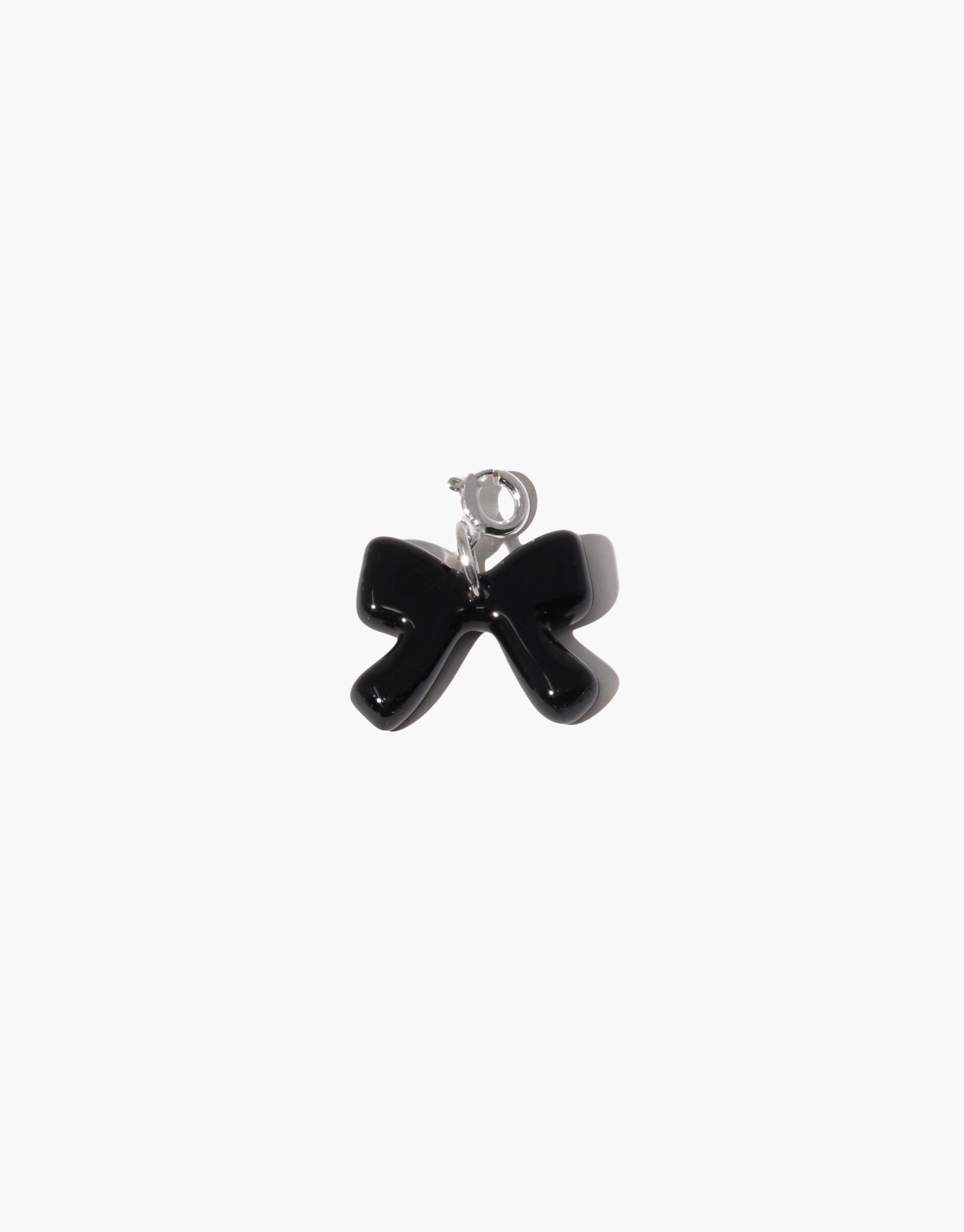 Elegant black bow-shaped charm with silver clasp, perfect for adding playful style to necklaces or bracelets. Bow A Icon Charm by CLED, a unique and versatile accessory for personalized jewelry creations.