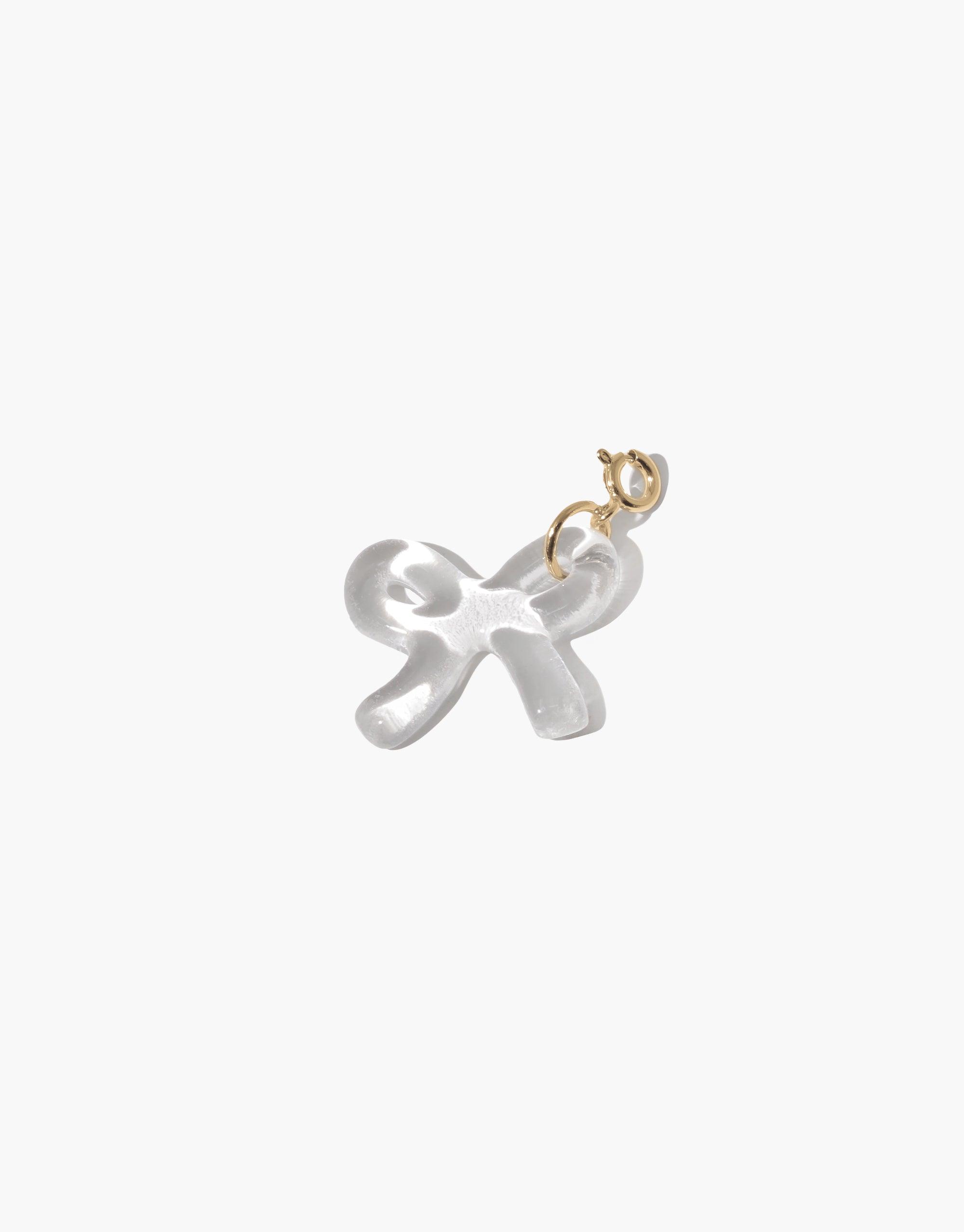 Elegant white bow-shaped charm with gold clasp, perfect for adding a playful touch to jewelry. Bow B Icon Charm features a delicate, feminine design, ideal for customizing necklaces or bracelets. CLED