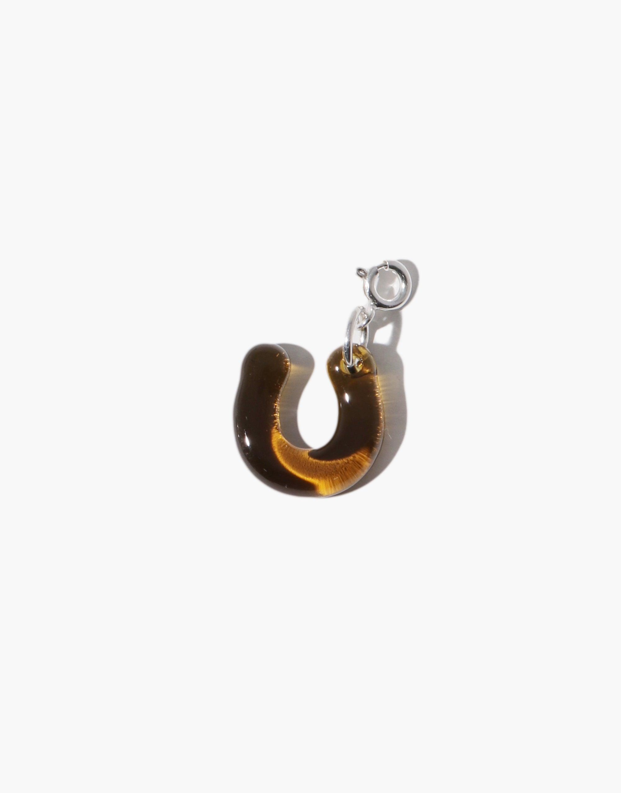 Horseshoe Icon Charm featuring a glossy amber-colored horseshoe pendant with silver attachments, displayed on a white background. Perfect for adding a touch of luck to jewelry designs. Horseshoe | Icon Charm by CLED