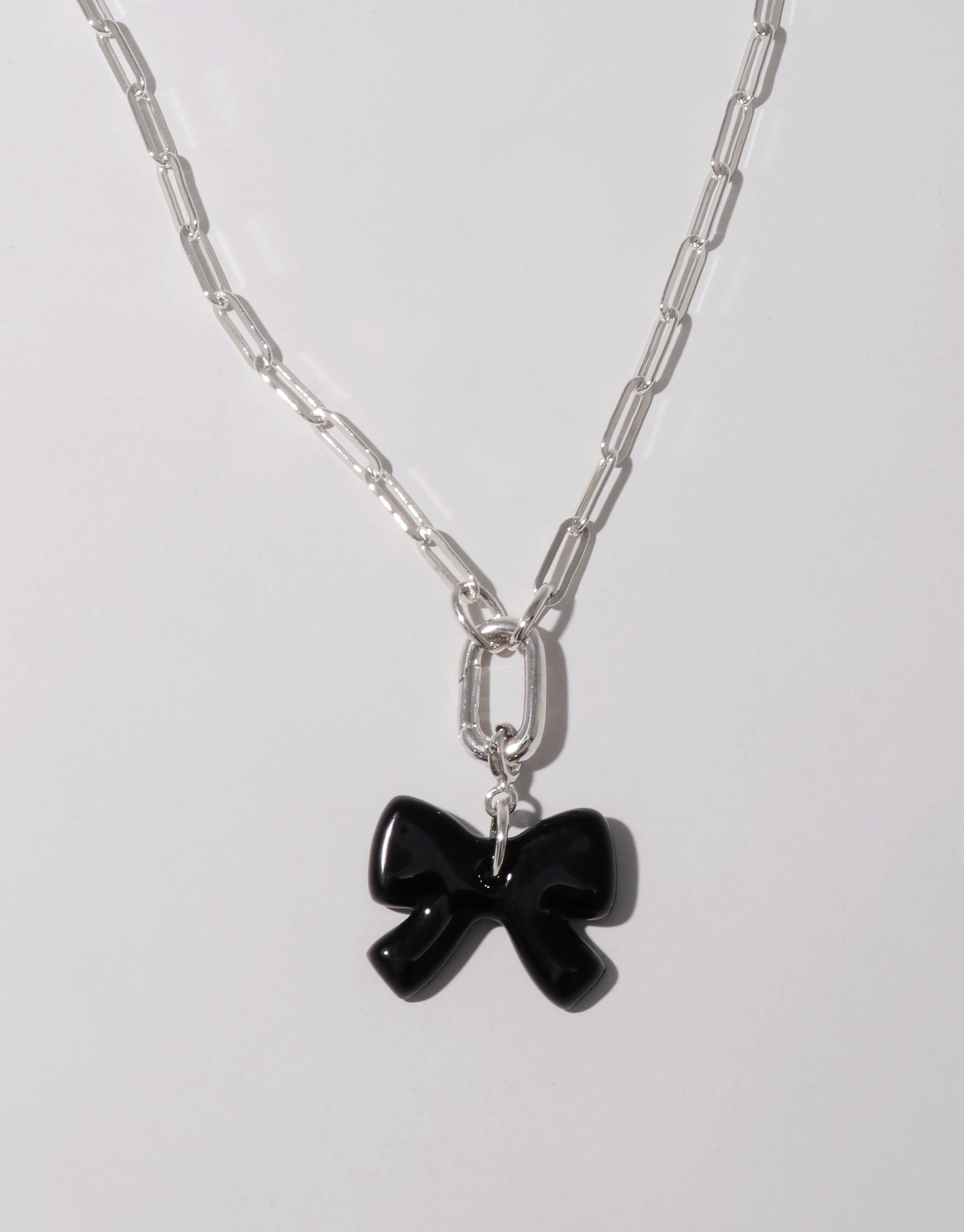 Elegant silver chain necklace featuring a charming black bow charm, perfect for customizing with additional icons or wearing as a standalone statement piece. Icon Chain Necklace | E by CLED