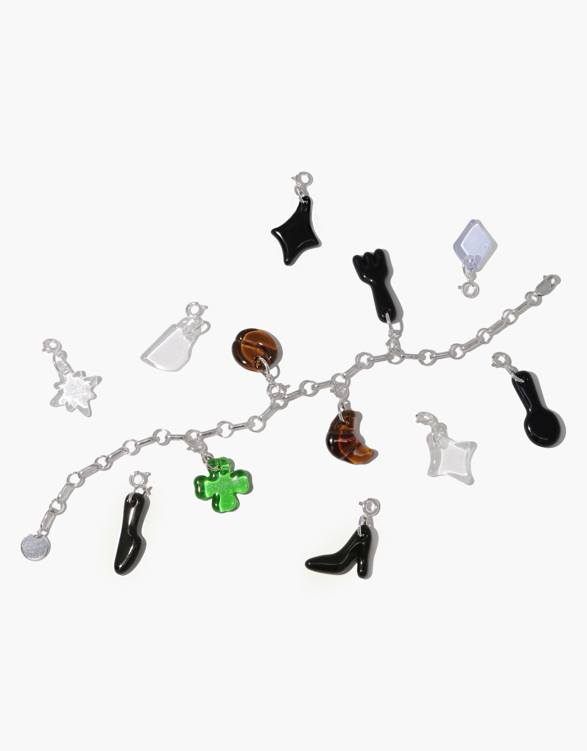 Silver charm bracelet with various icon charms including a fork, shoe, star, and geometric shapes in black, white, green, and amber colors. Playful and distinctive accessories for customizing jewelry. Fork | Icon Charm by CLED