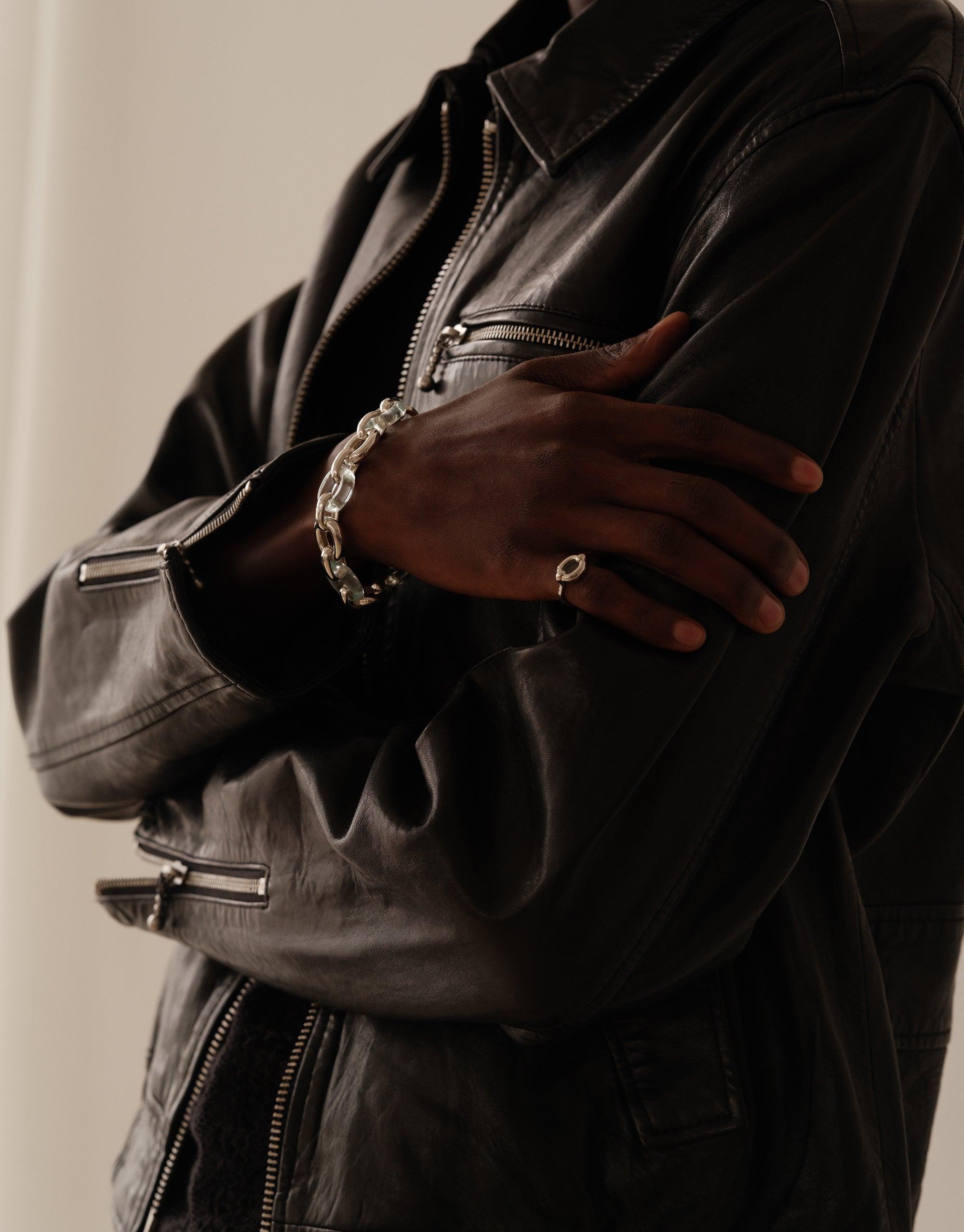 Stylish Connected Loop Bracelet in mixed metal and glass, worn on wrist crossed over chest in black leather jacket, symbolizing unity and upcycled fashion. Connected Loop Bracelet | Mixed Metal & Glass by CLED