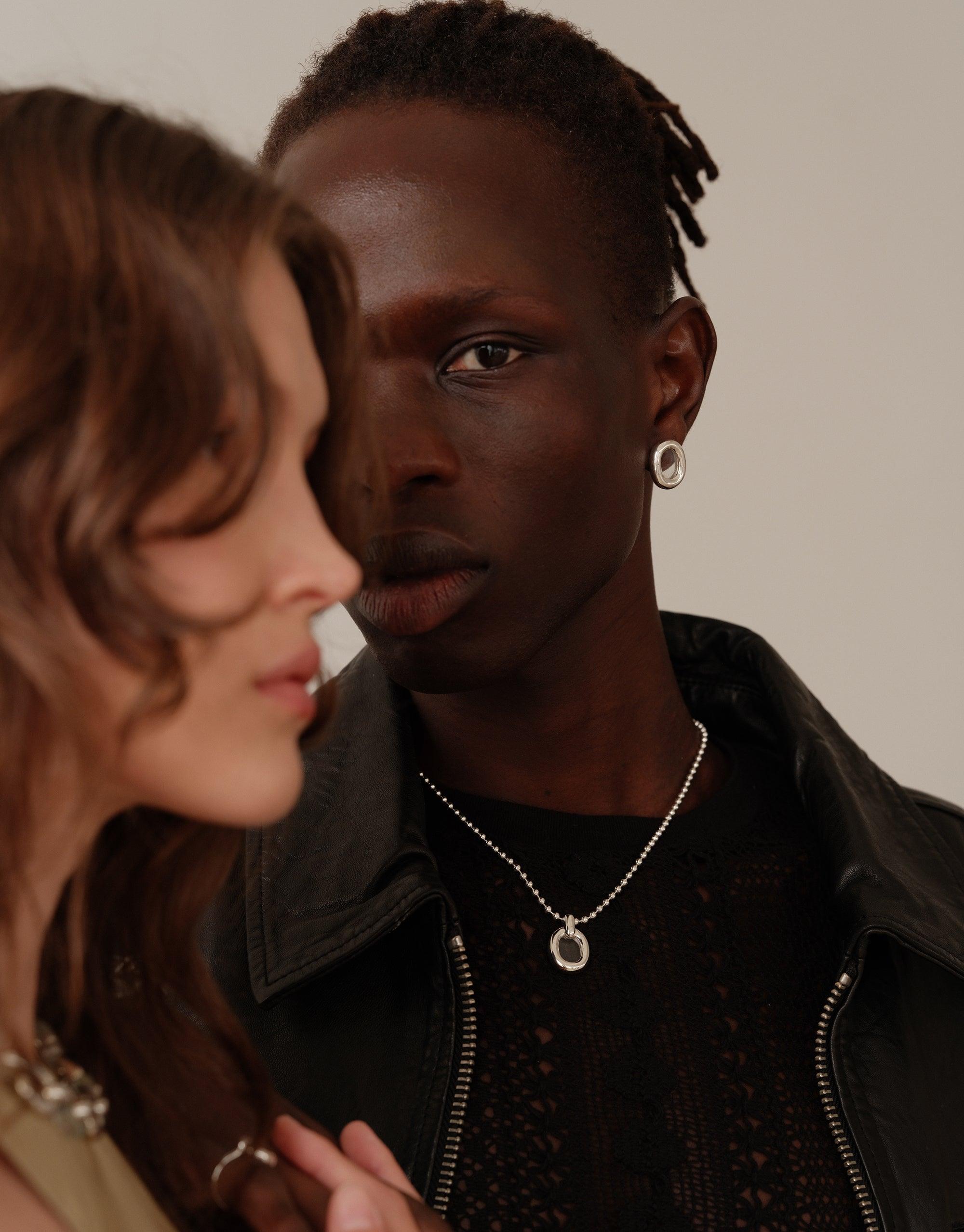 Stylish couple showcasing the elegant Core Loop Necklace, a refined ball chain design that embodies unity and sustainability. The necklace adds a subtle sparkle to their intimate pose, reflecting CLED's commitment to upcycled beauty. Core Loop Necklace | Ball Chain by CLED