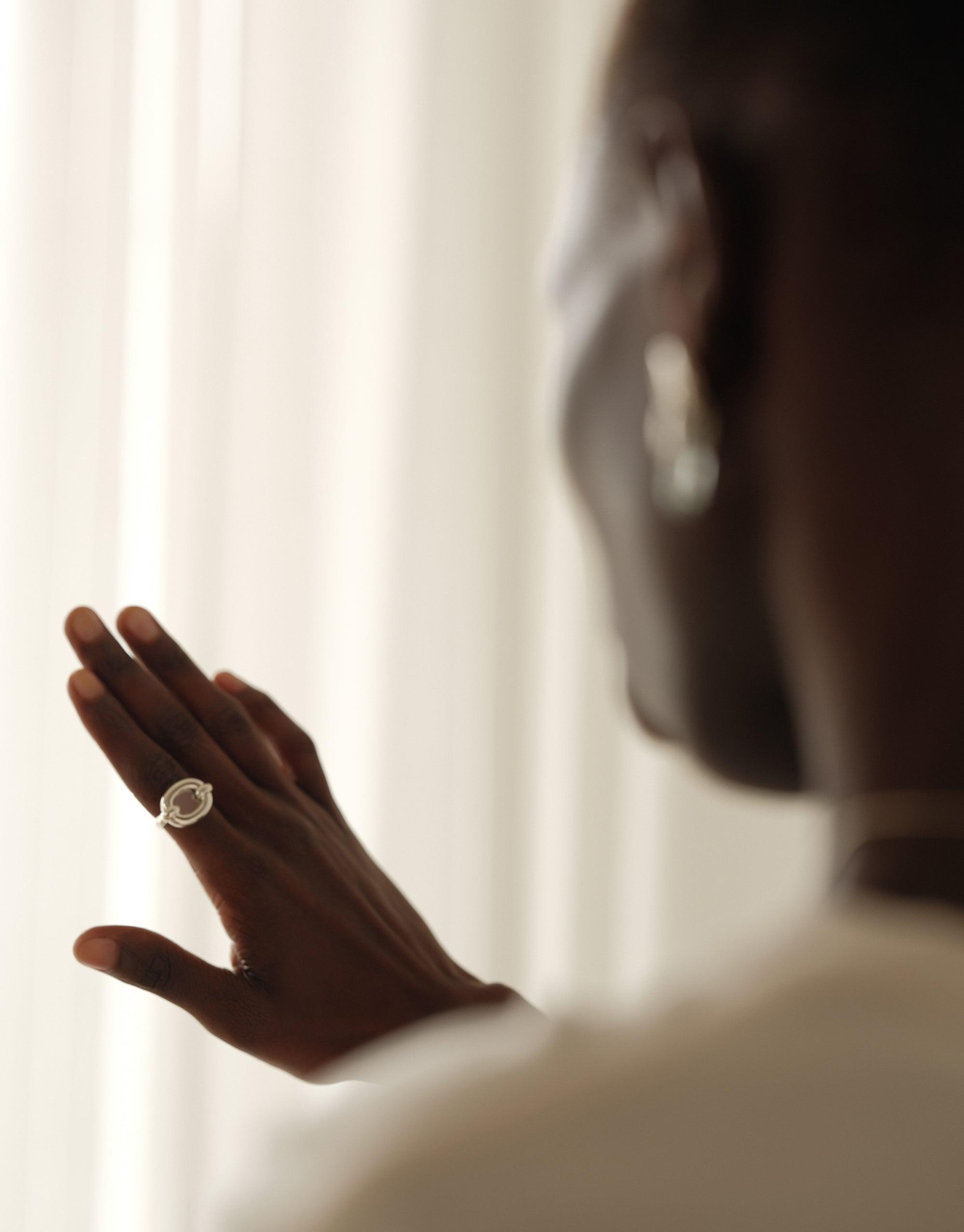 Elegant hand modeling Core Loop Ring | Large, showcasing mirror-like surface reflecting soft light. Unique eco gem setting encased in metal, creating a striking core accent. Versatile accessory for quick personal checks or capturing moments. CLED