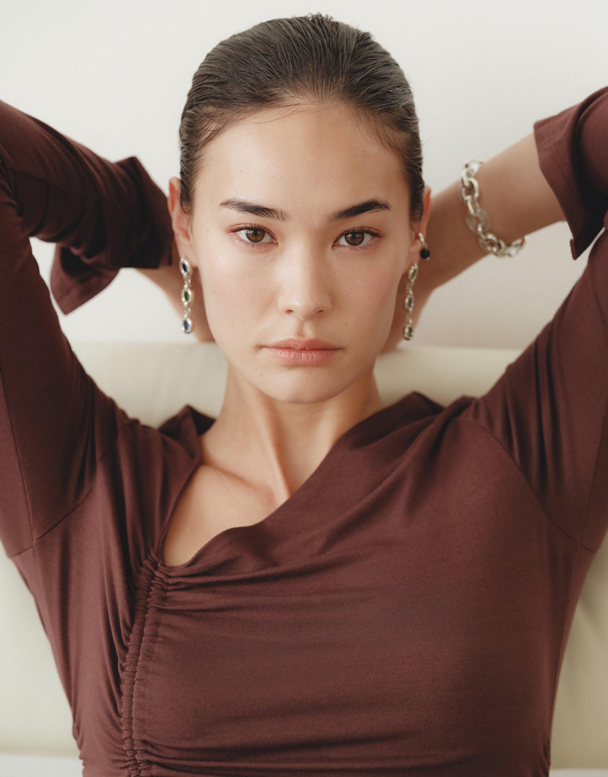 Trio Core Loop Earrings showcased by a woman with hands behind her head, highlighting CLED's eco-conscious, upcycled jewelry crafted from repurposed glass, embodying unity and sustainable elegance.