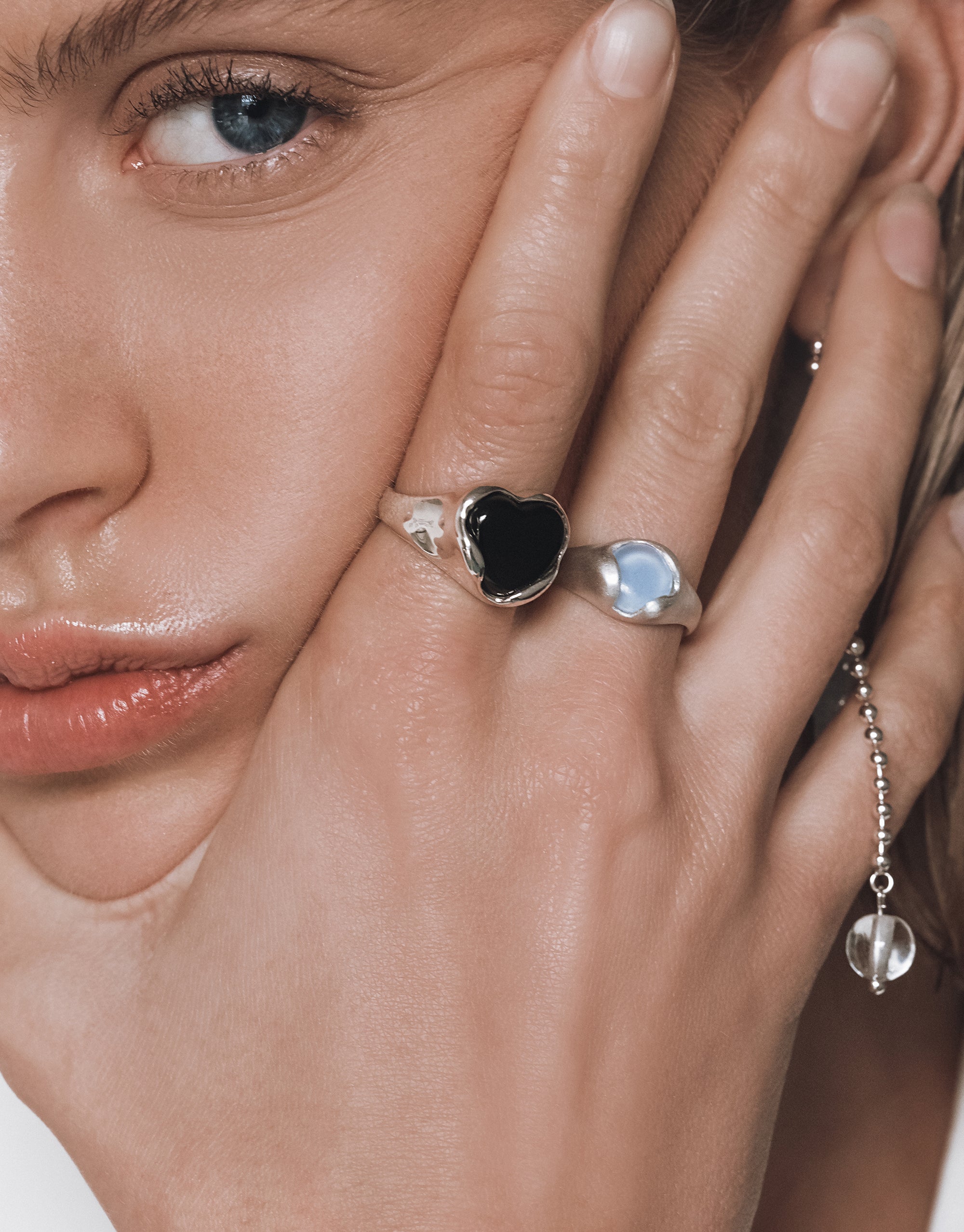 Hand wearing elegant Orb Ring with black heart and clear glass accents shown against soft skin - CLED