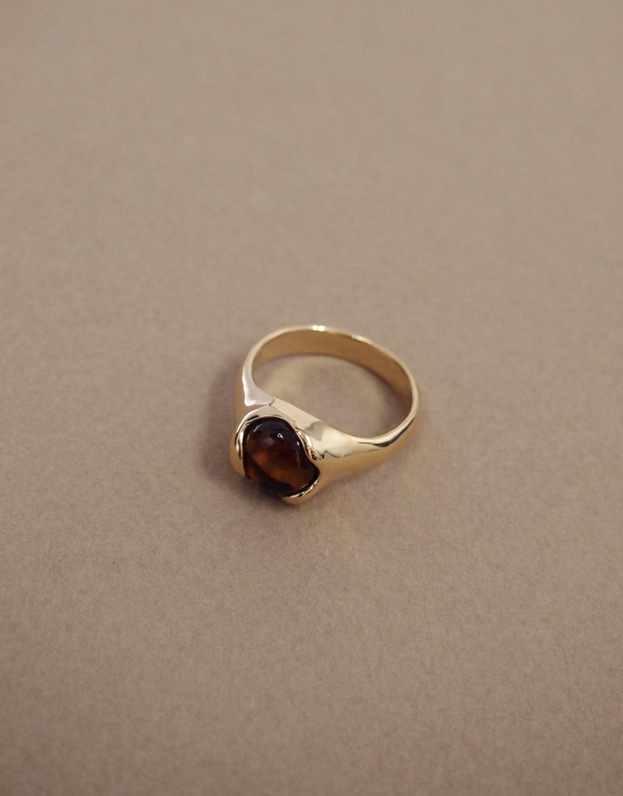 Orb Ring: A gold band elegantly holds a unique brownish-amber Eco Gem cabochon, embodying serenity and balance, reflecting CLED's eco-conscious craftsmanship and commitment to sustainable beauty.