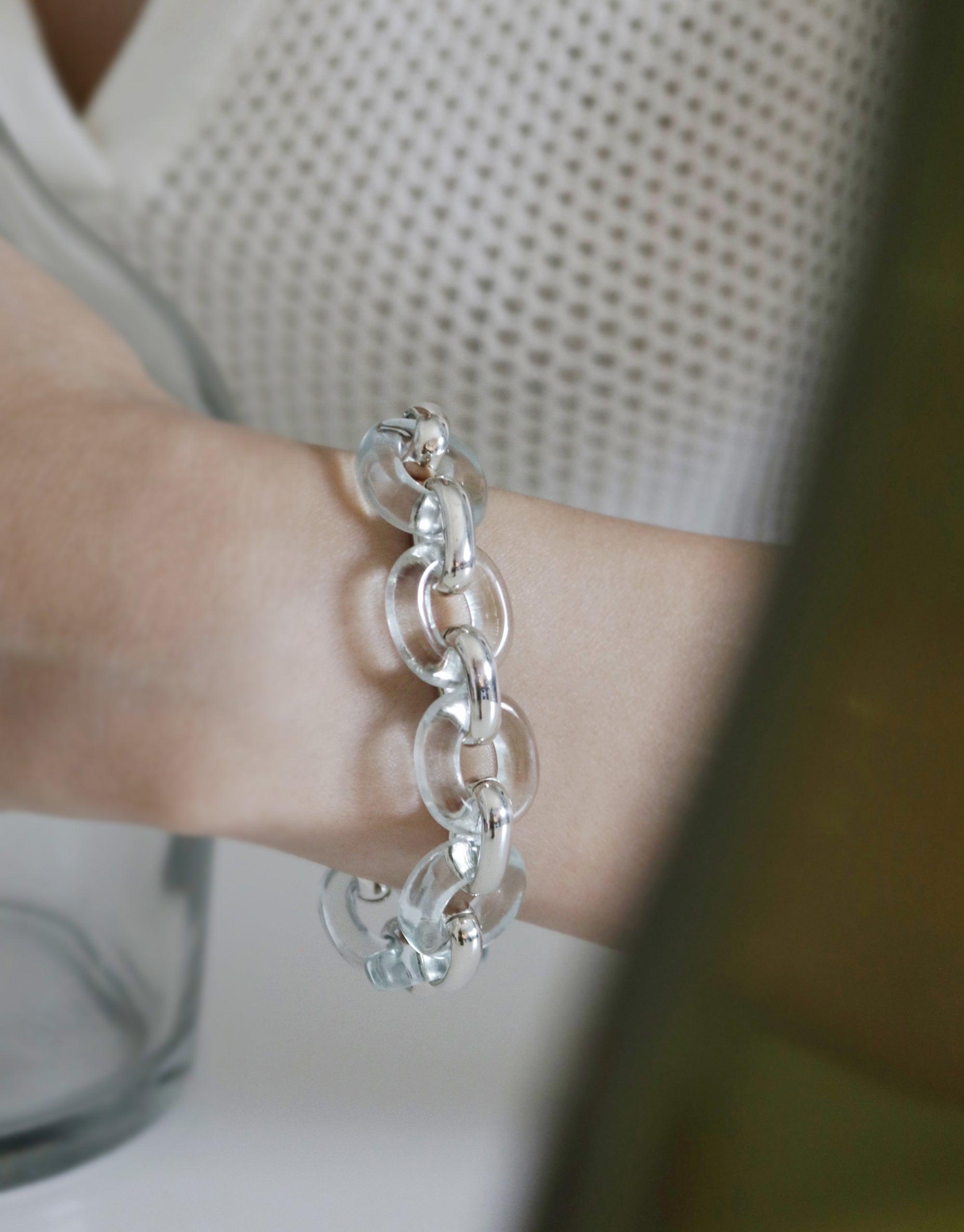 Close-up of Connected Loop Bracelet | Glass on a wrist, showcasing interlocking transparent glass loops with silver connectors. Elegant and sustainable design symbolizing unity and upcycling. Part of the In The Loop collection by CLED.