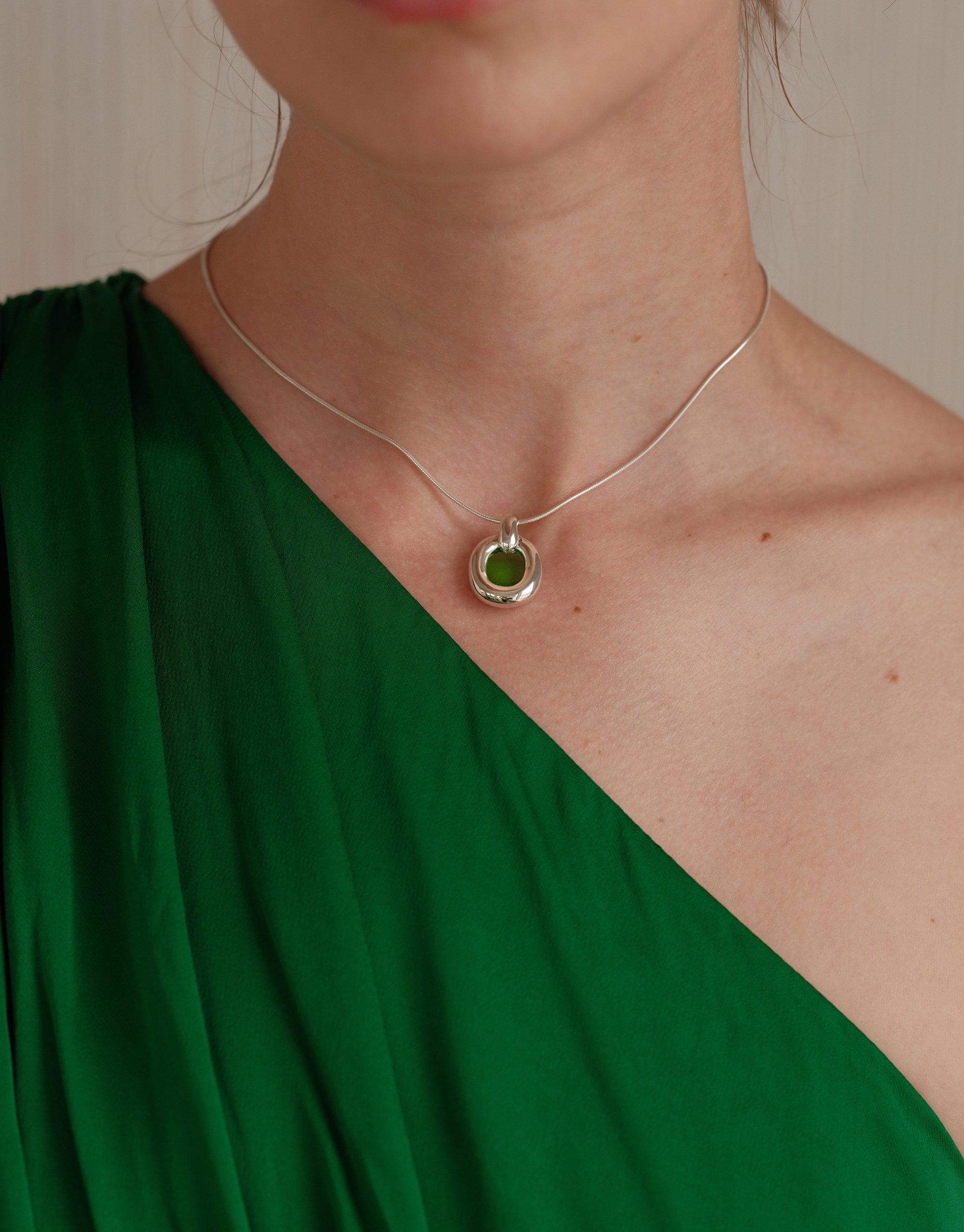Elegant Core Loop Necklace with green pendant on silver snake chain, worn by model in emerald green dress. Showcases sustainable upcycled jewelry design. Core Loop Necklace | Snake Chain by CLED