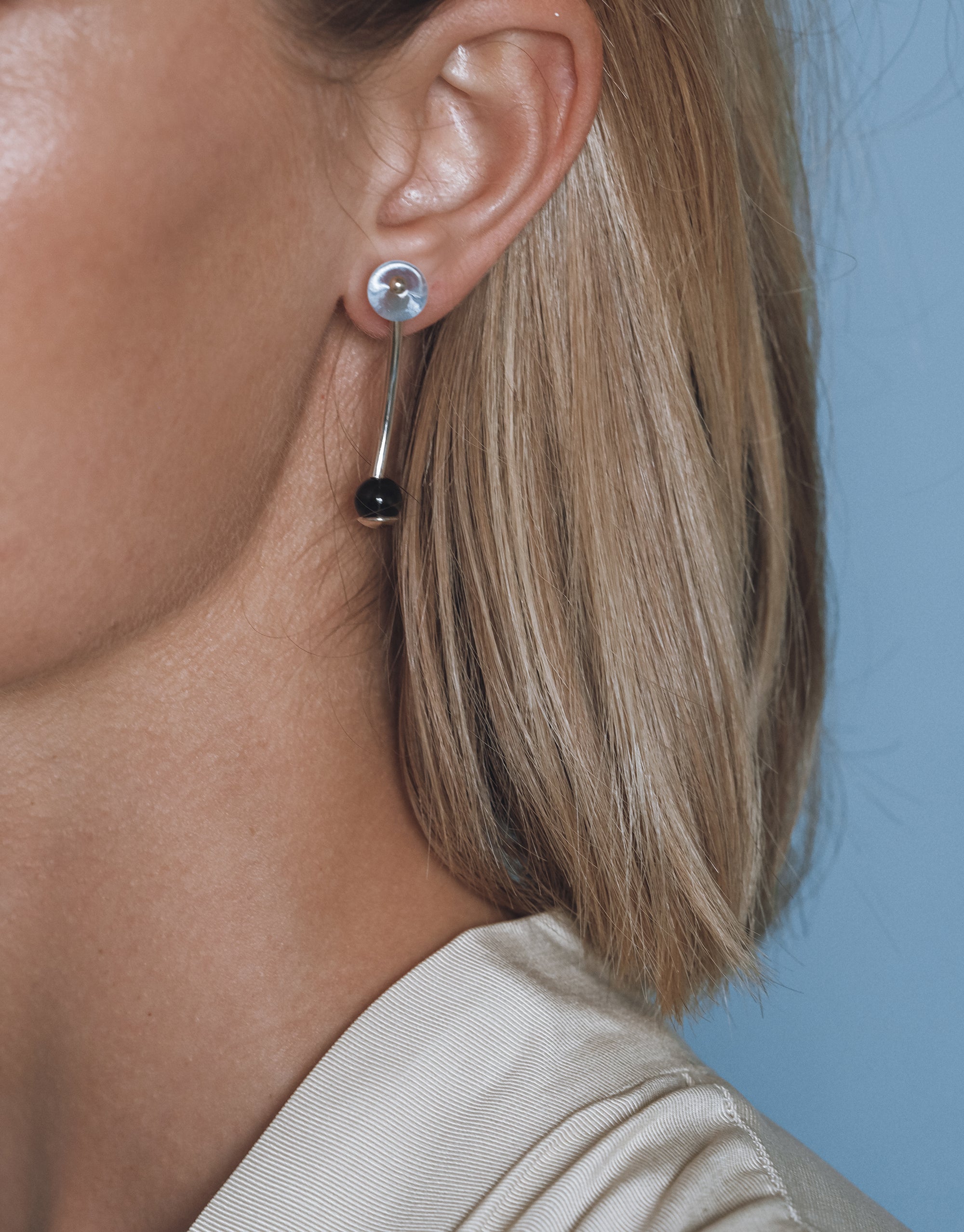 Halo Earrings featuring curved silver design with glass sphere accents, shown on ear with elegant drop style - by CLED