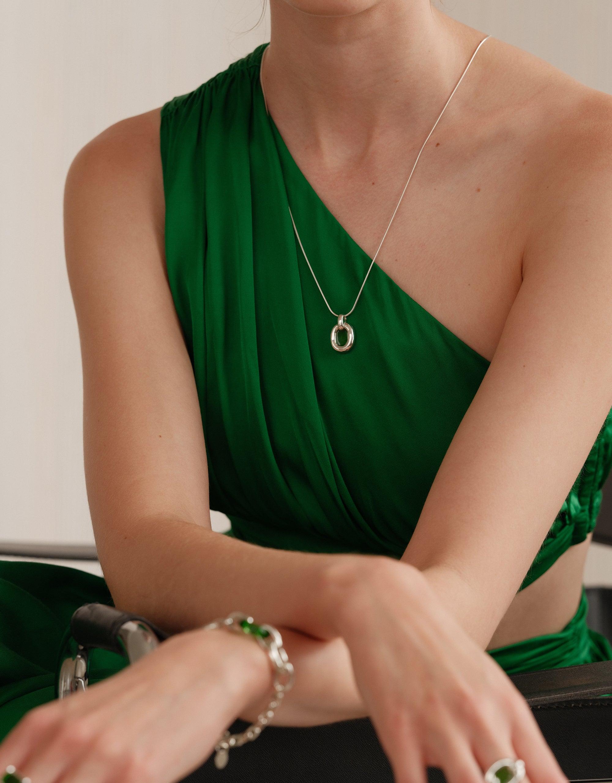 Elegant Core Loop Necklace with snake chain worn by model in green one-shoulder dress, showcasing CLED's sustainable jewelry design. Core Loop Necklace | Snake Chain by CLED