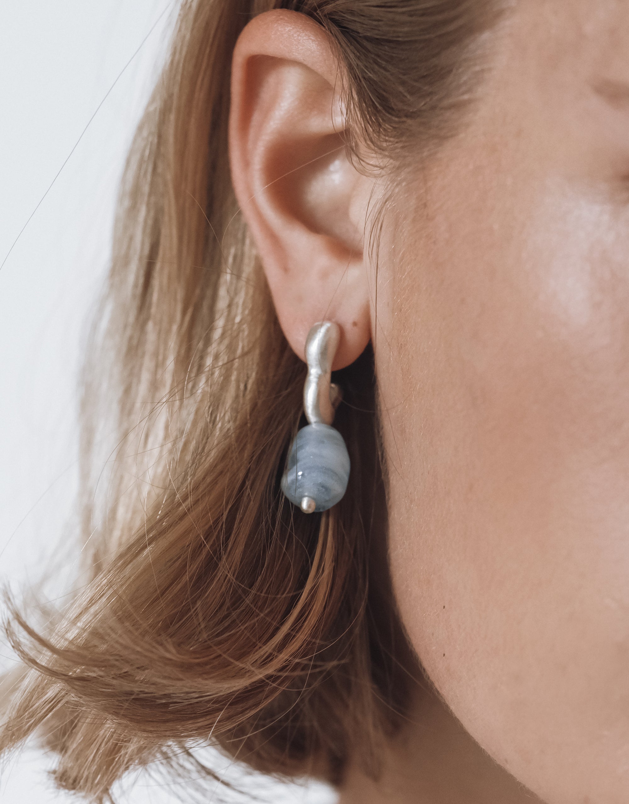 Flow Drop Hoop Earrings with sculptural silver hoops and gray glass drop pendant, showcasing organic flowing design by CLED