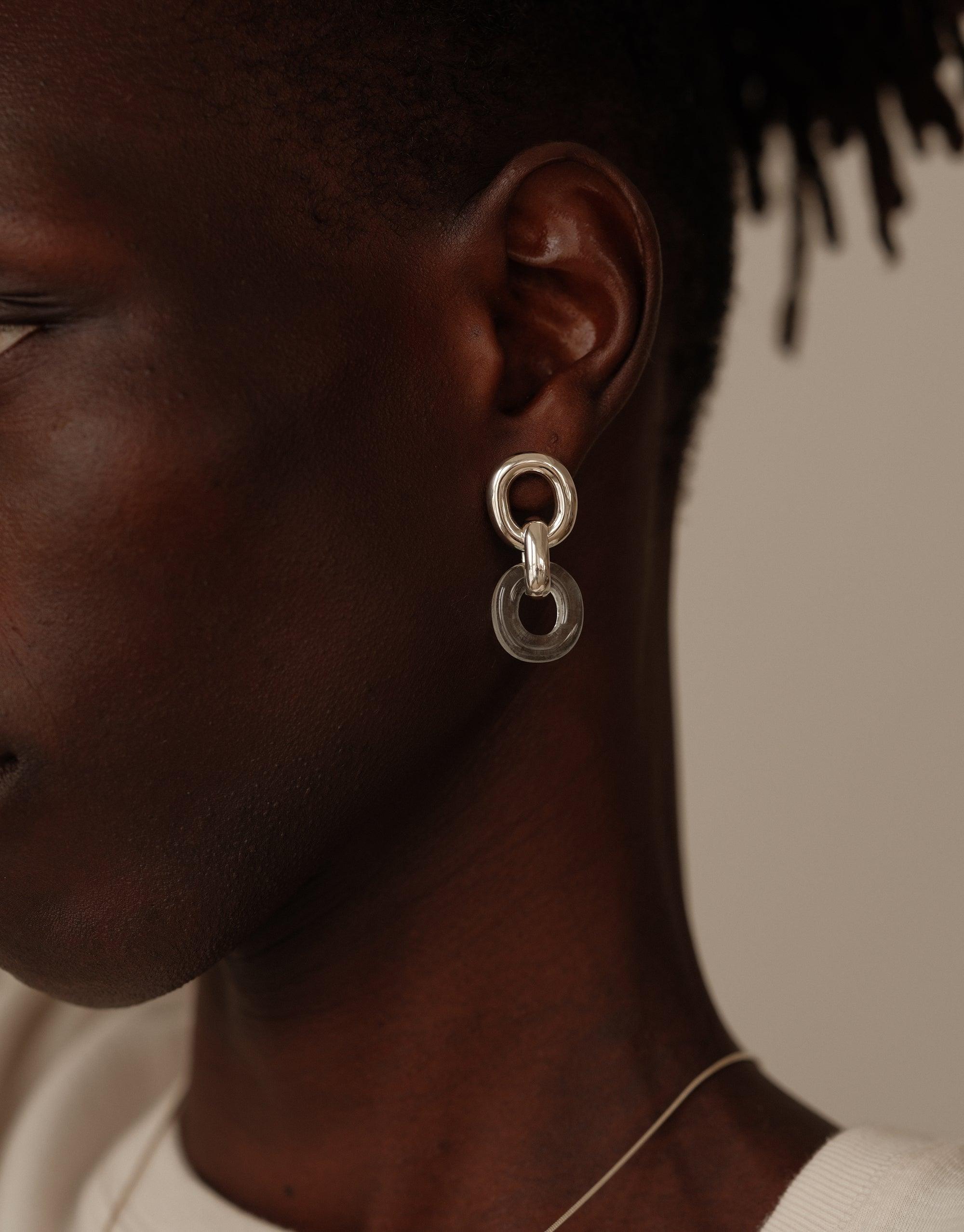 Close-up of Connected Loop Earrings, featuring interlocking silver and clear circular elements, showcasing elegant design and upcycled materials. Symbolic of unity and connection, these earrings embody the In The Loop collection's ethos. Connected Loop Earrings by CLED.