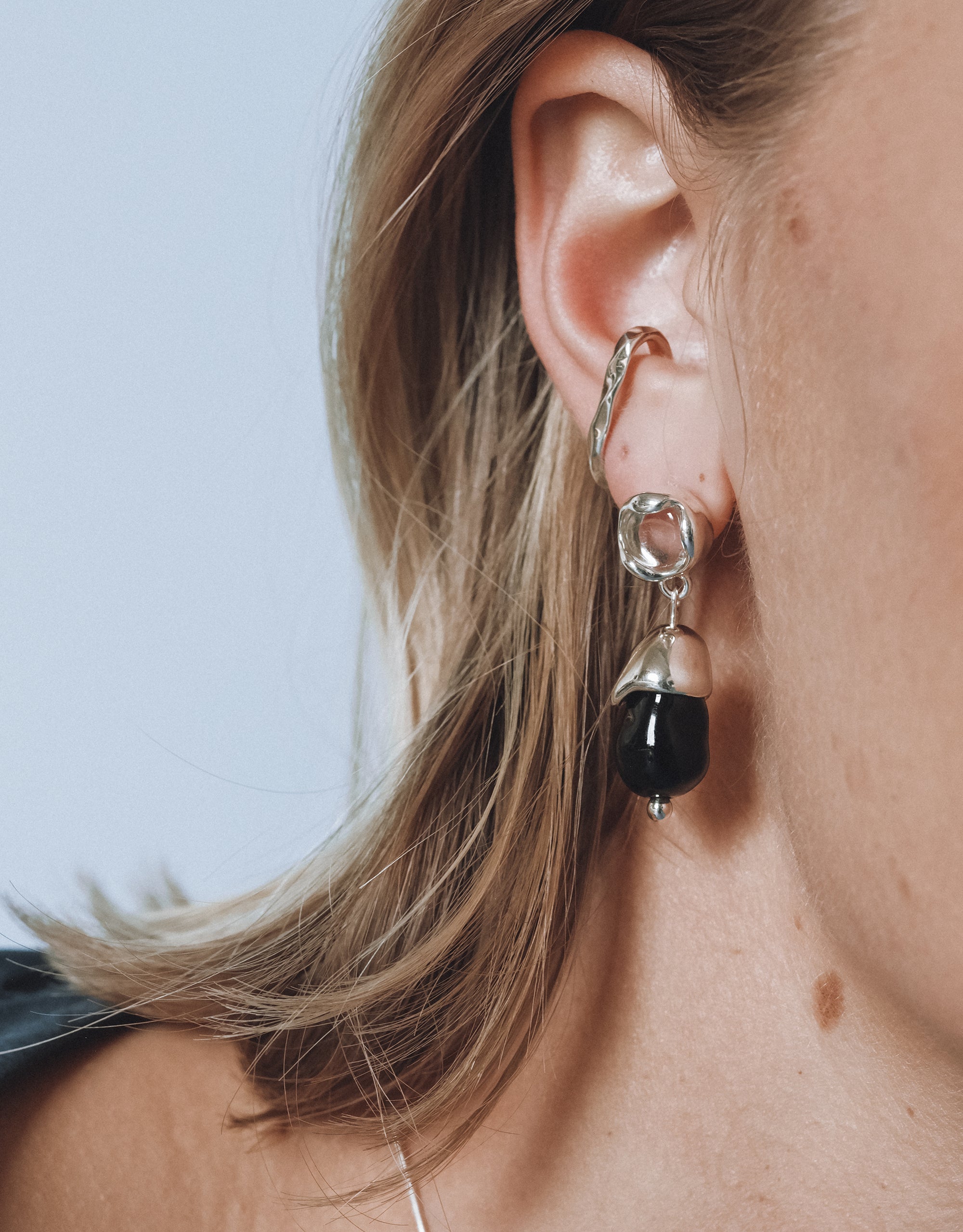 Solace Drop Earrings with curved silver details and black glass pendant showcasing organic sculptural design by CLED