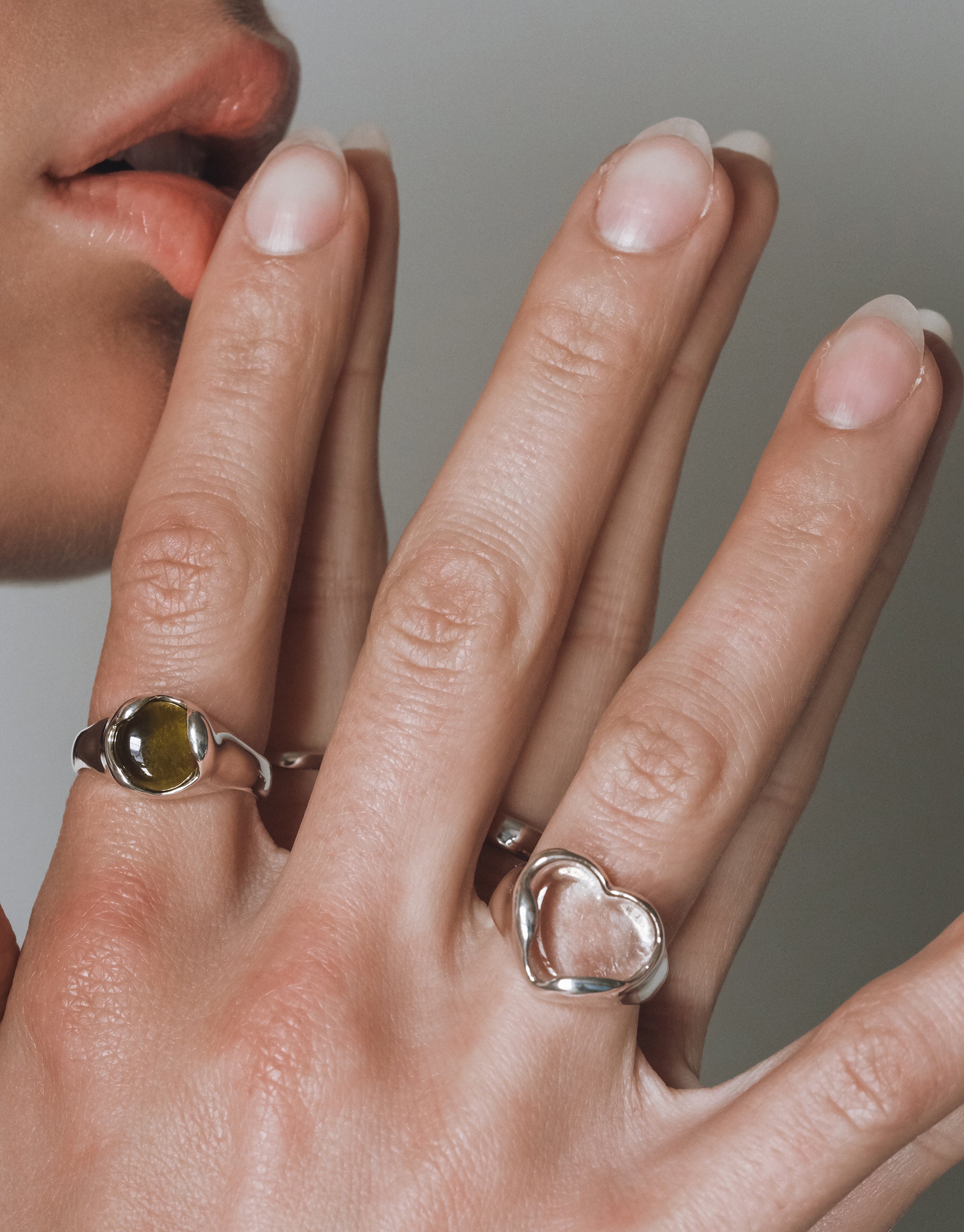 Silver Orb Ring with green eco gem center in elegant curved setting shown on hand with natural manicure - CLED