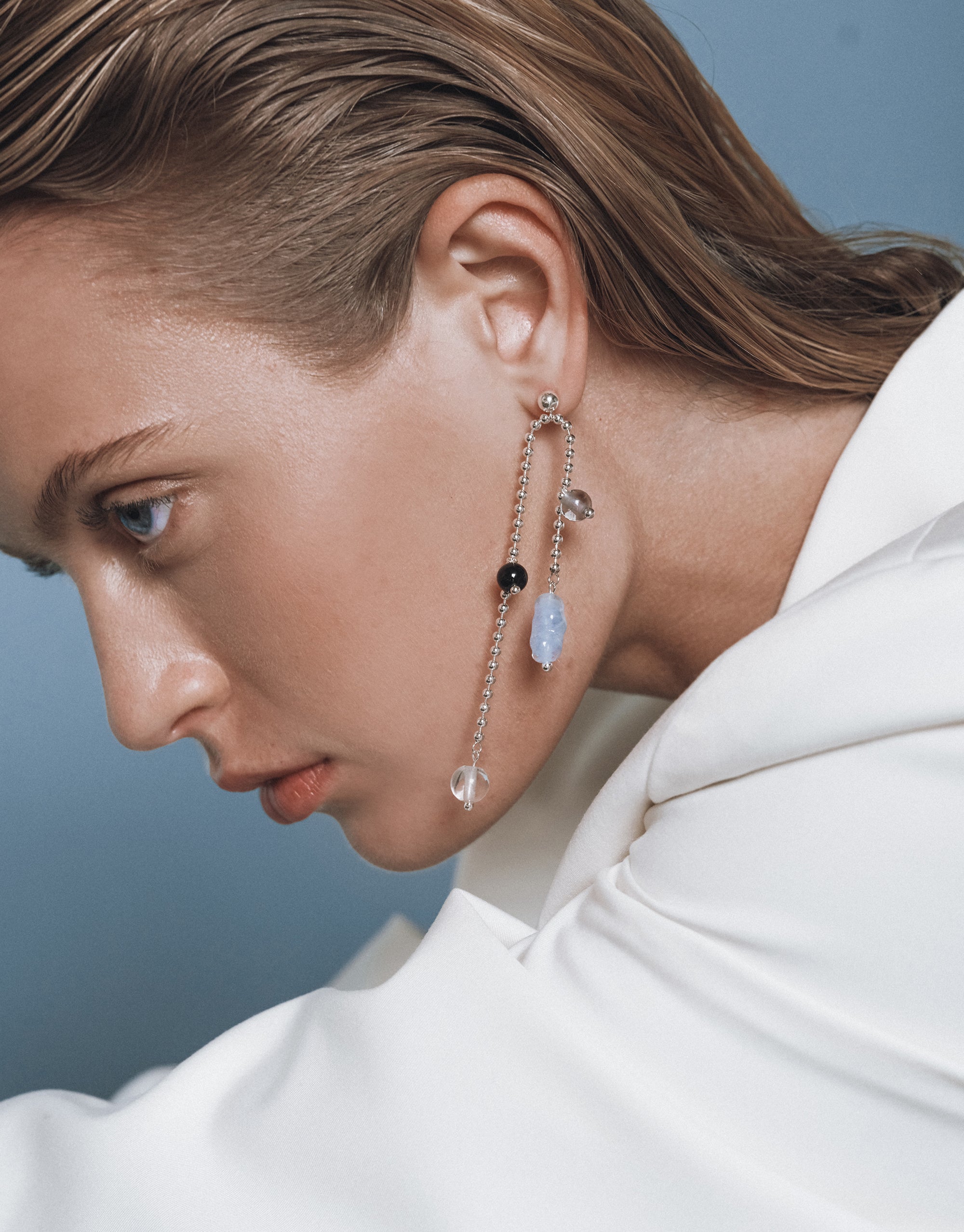 Elegant asymmetrical Still Earrings with delicate beaded chain design and crystal accents, shown on model - by CLED