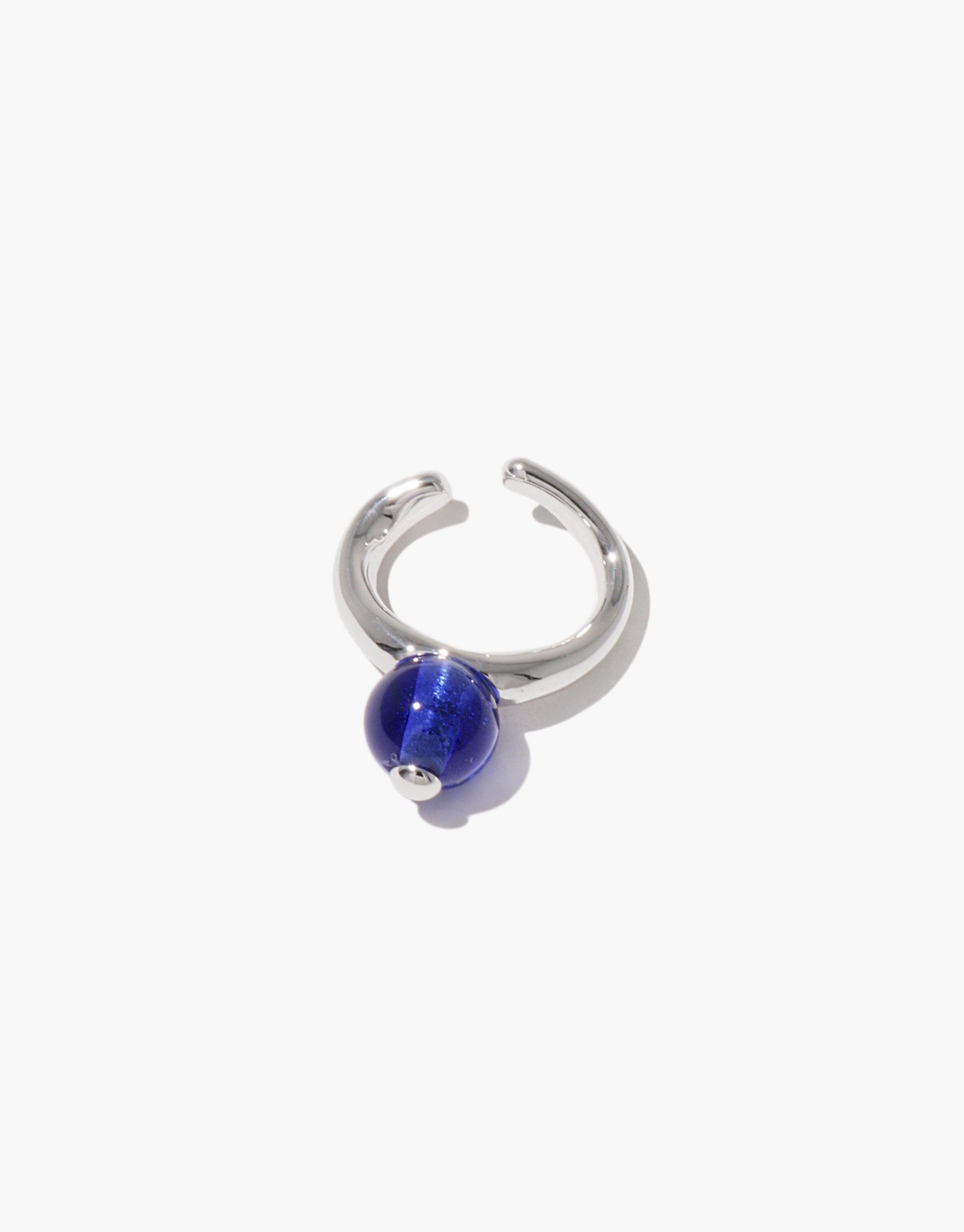 Silver ear cuff with a vibrant blue spherical bead, inspired by nature's organic shapes. Pea Ear Cuff | Small showcases elegant simplicity and transformation, perfect for everyday wear. CLED